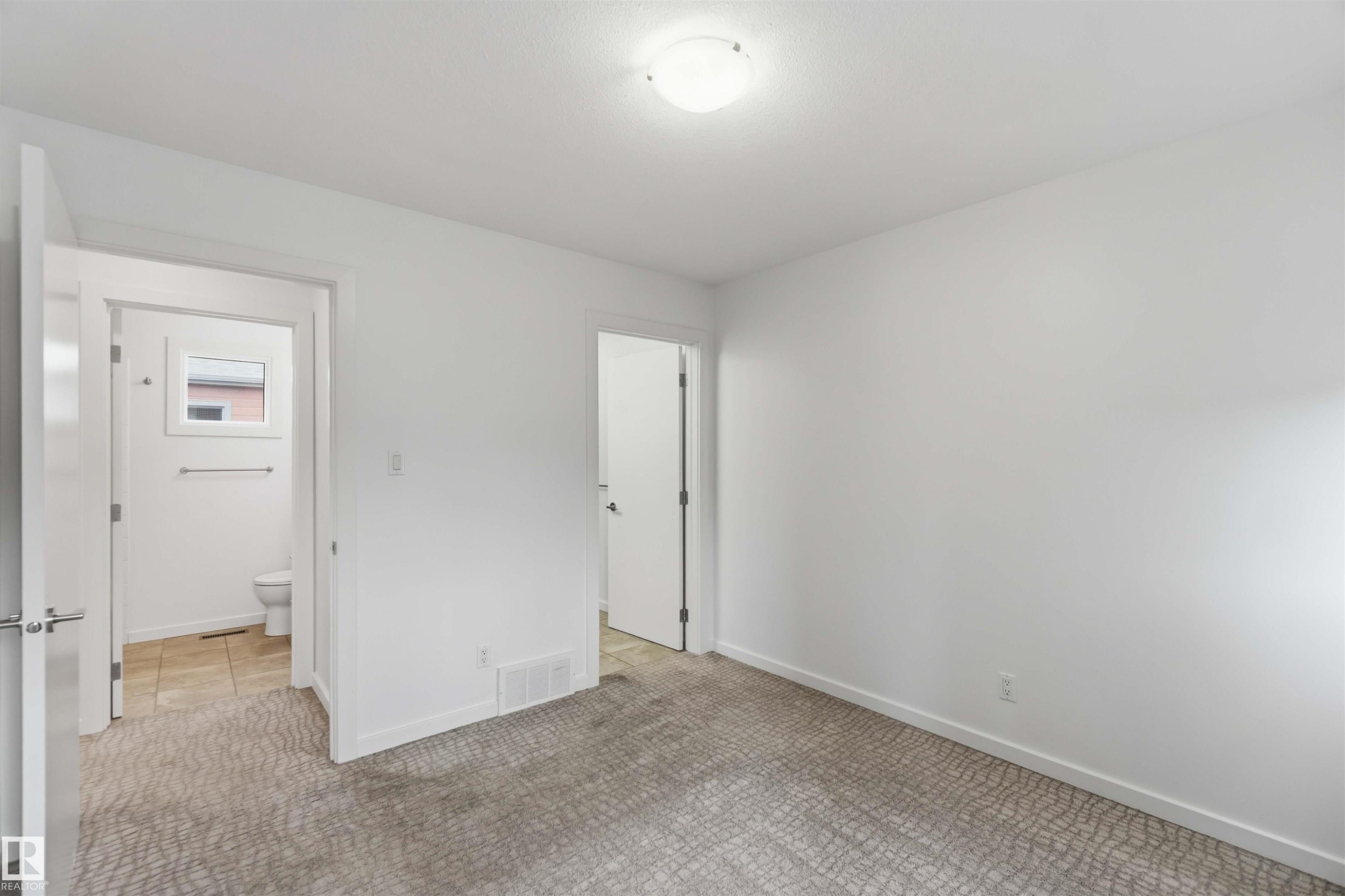 Room featuring patterned carpeting, white walls, and a flush-mount ceiling light - #1 14315 Stony Plain Nw, Edmonton, AB - Indoor Photo Showing Other Room