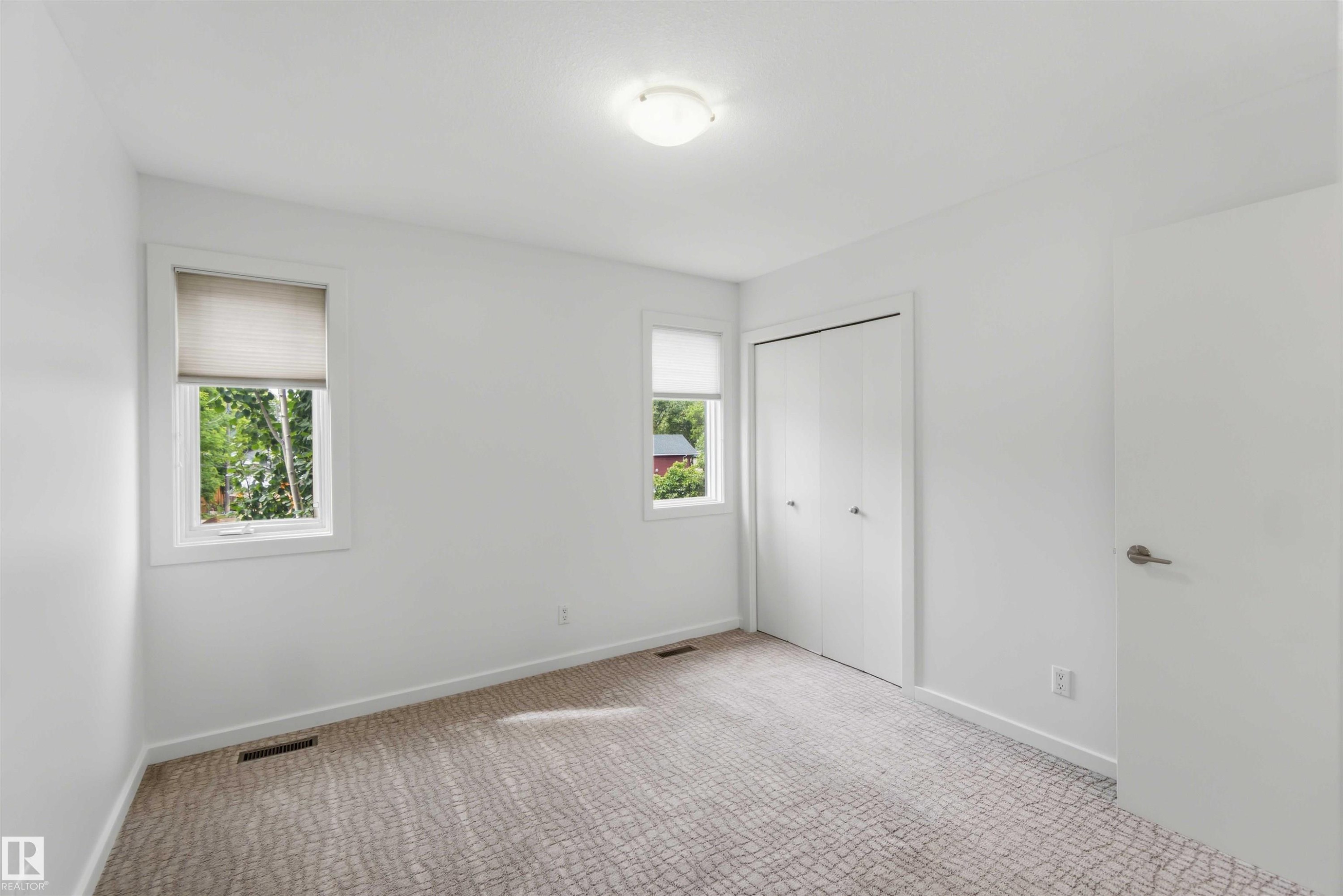 Neutral-toned carpeting complements white wall finishes - #1 14315 Stony Plain Nw, Edmonton, AB - Indoor Photo Showing Other Room