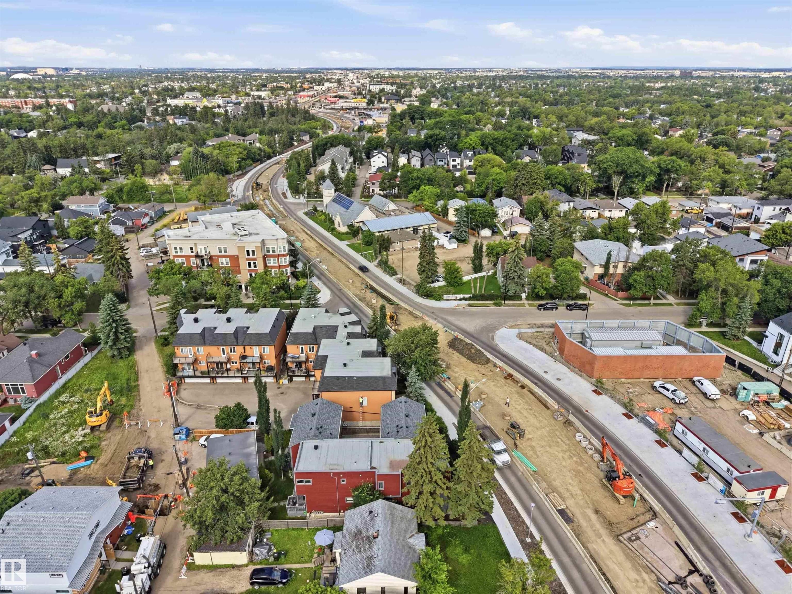 Aerial perspective showcasing extensive urban development, including multi-story residential buildings, single-family homes, and new infrastructure projects - #1 14315 Stony Plain Nw, Edmonton, AB - Outdoor With View