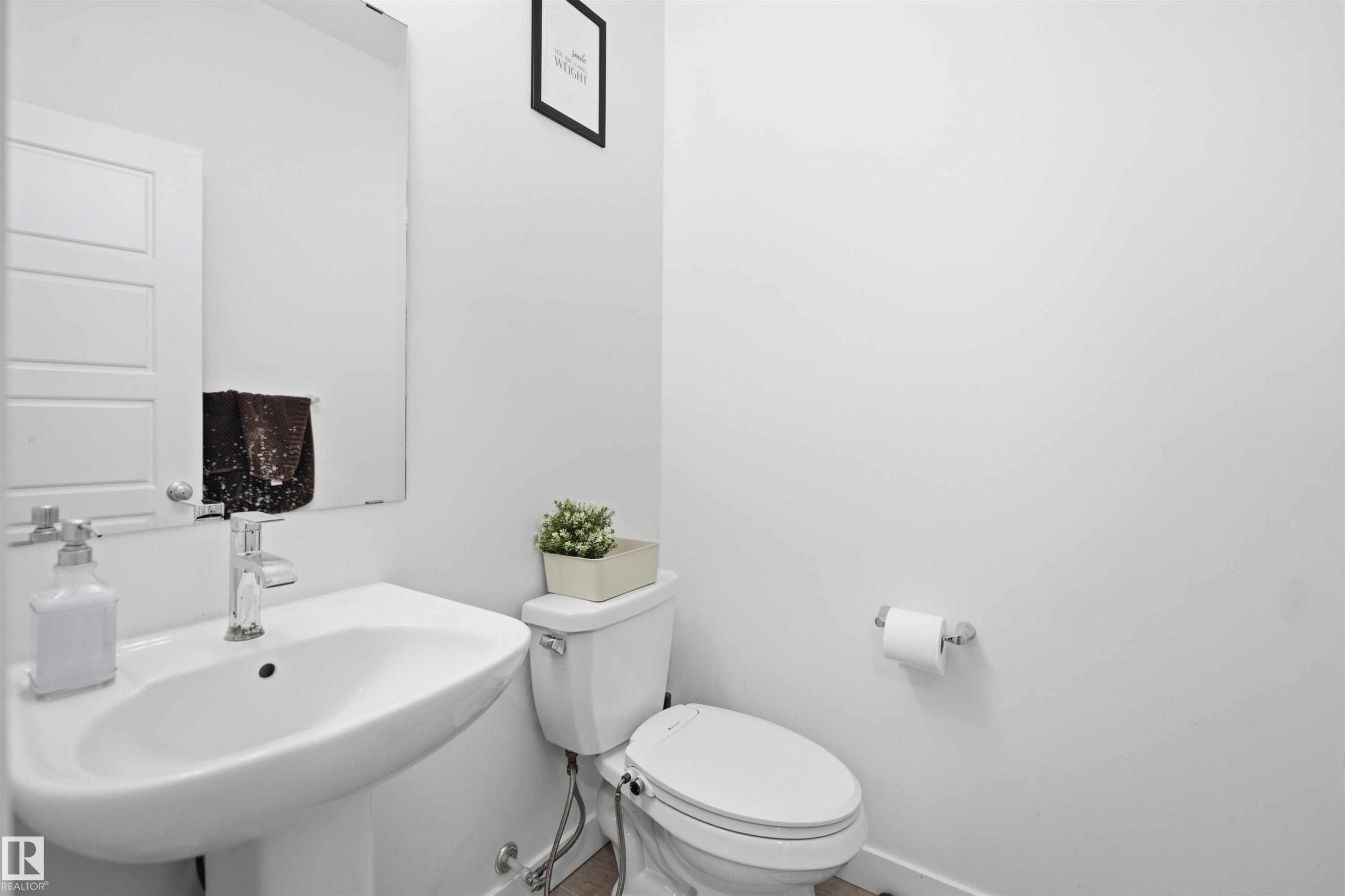 Pedestal sink with chrome faucet, complemented by a wall-mounted mirror - 2508 193 Street Nw, Edmonton, AB - Indoor Photo Showing Bathroom
