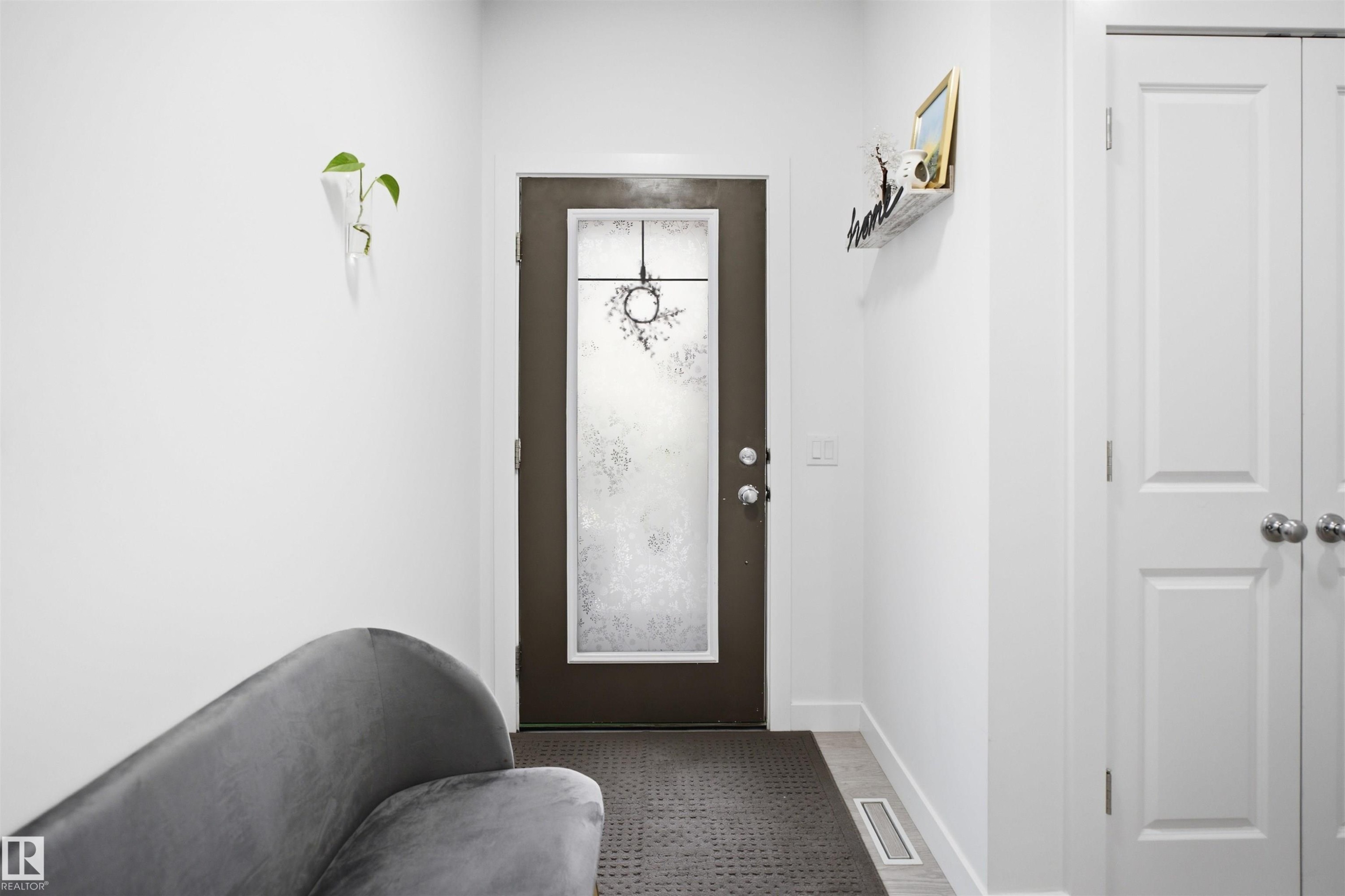 Entryway featuring a dark-framed door with frosted glass, white interior walls, and light-toned flooring - 2508 193 Street Nw, Edmonton, AB - Indoor Photo Showing Other Room