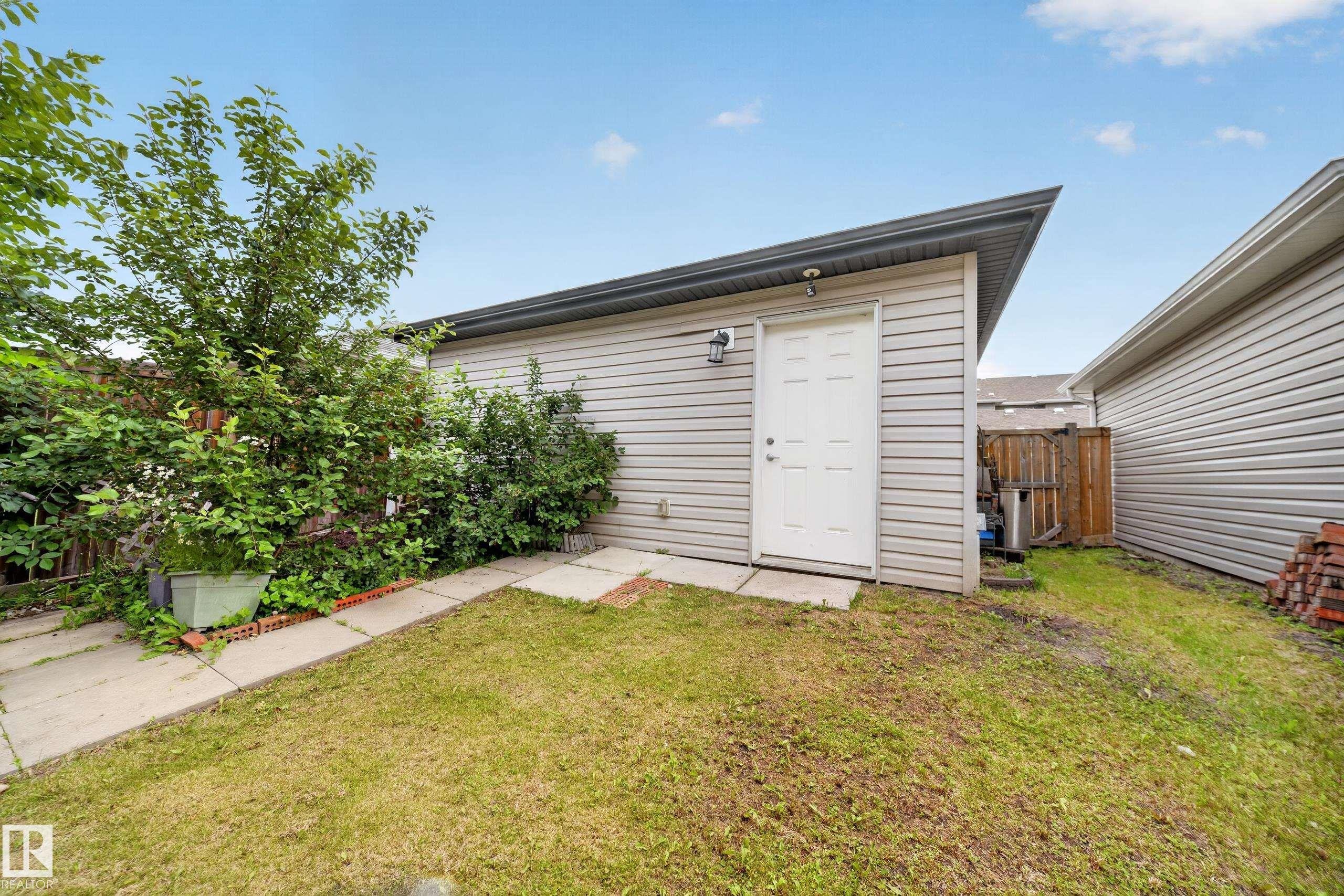 Detached garage with horizontal siding and a single entry door - 227 Cy Becker Blvd, Edmonton, AB