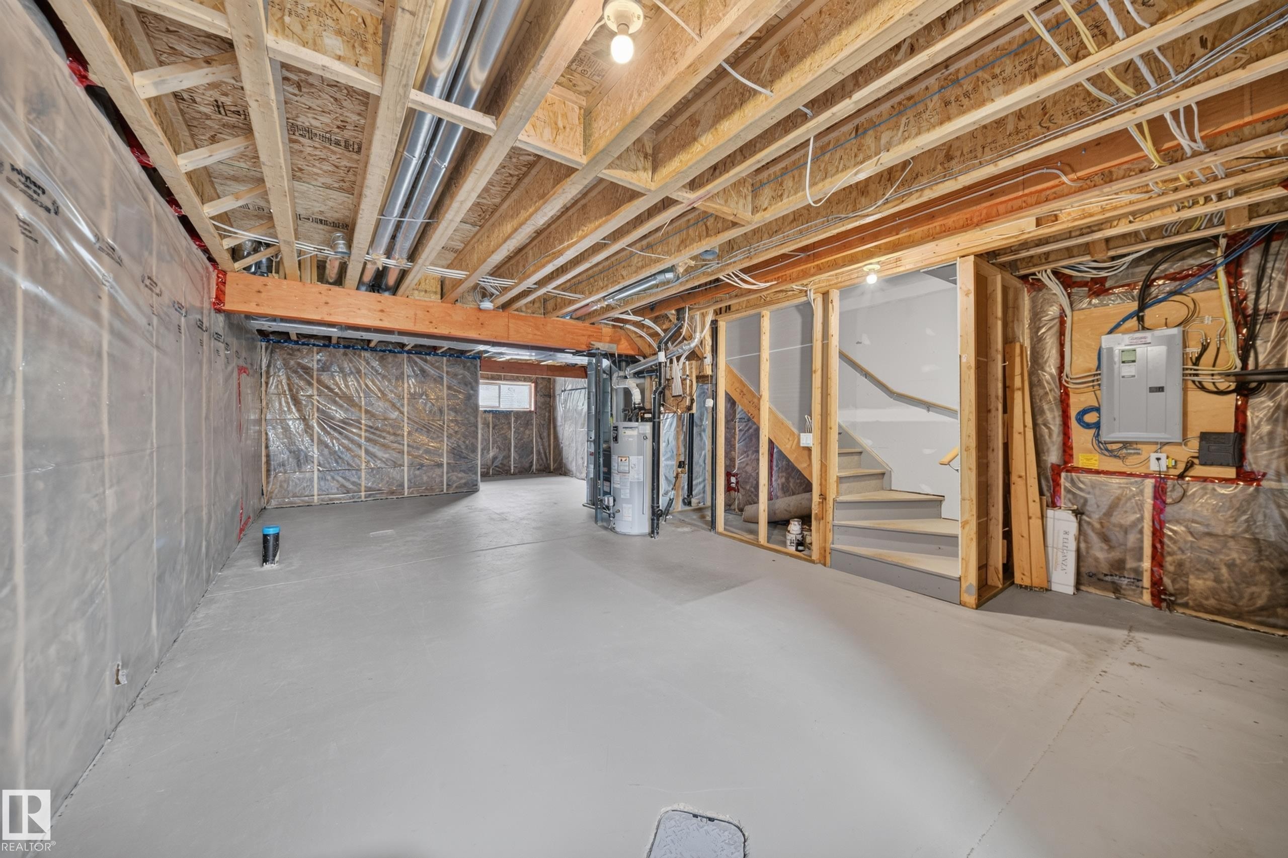Unfinished basement with exposed wood framing, concrete flooring, and visible plumbing and electrical infrastructure - 227 Cy Becker Blvd, Edmonton, AB