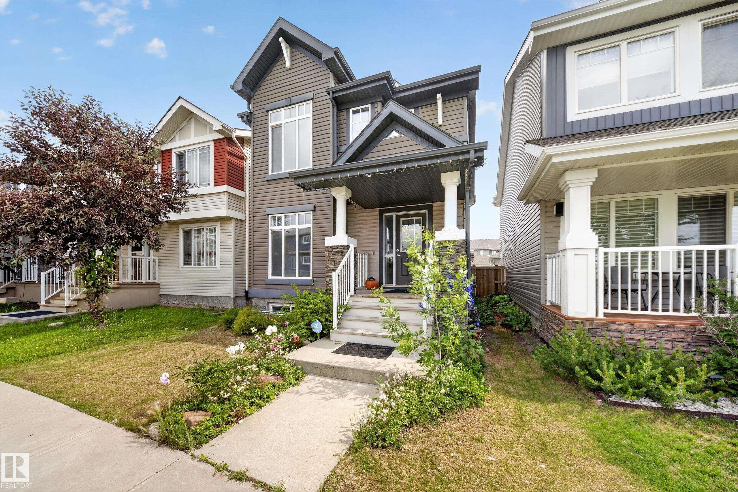 Two-story home with dark siding and white trim - 227 Cy Becker Blvd, Edmonton, AB