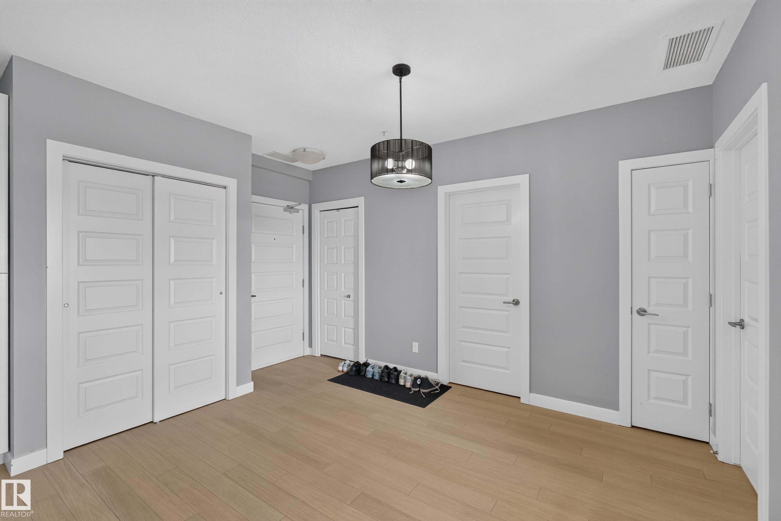 Neutral gray painted walls with wood-finish flooring - 706 5151 Windermere Boulevard, Edmonton, AB