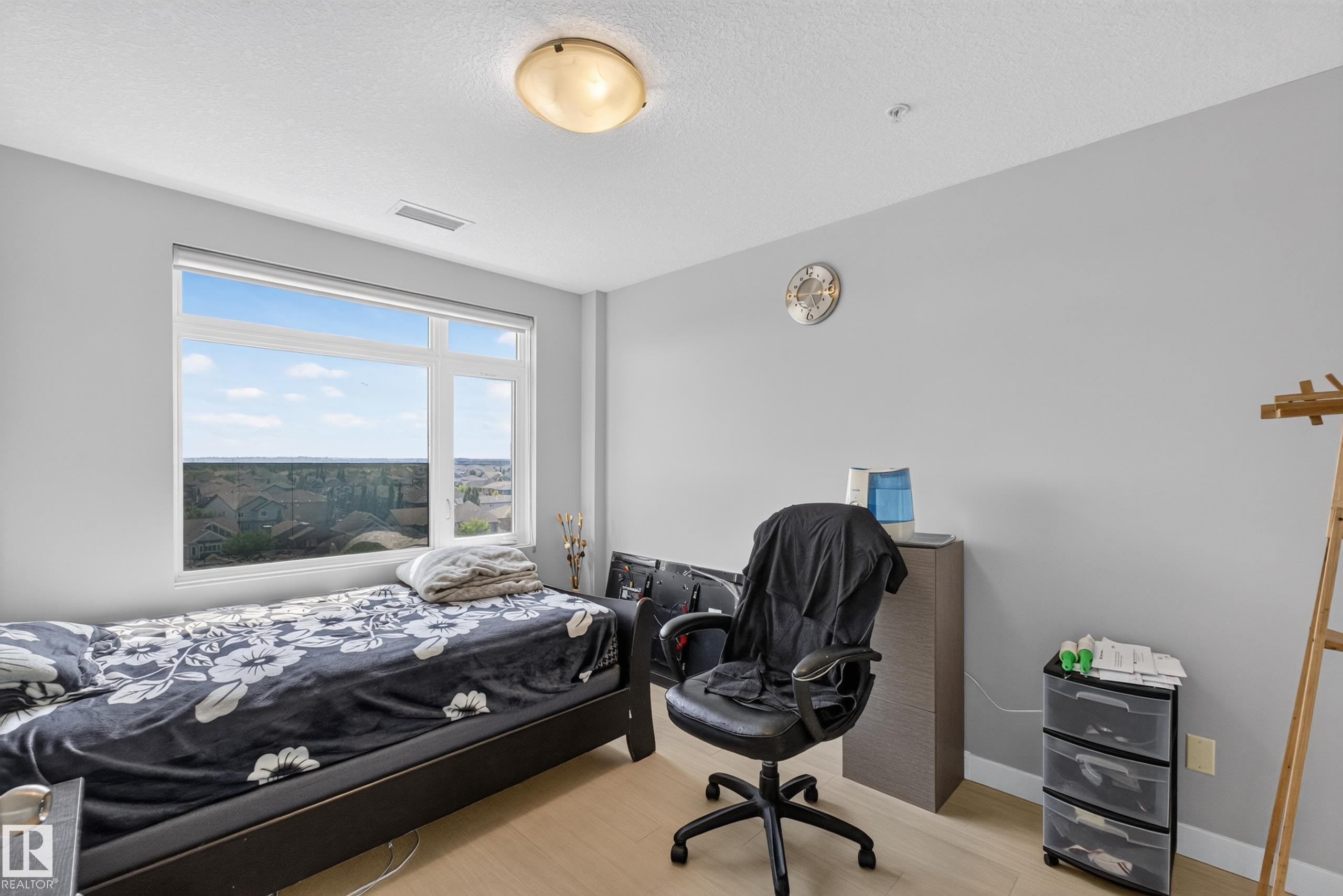 Room featuring light wood-finish flooring and a large window - 706 5151 Windermere Boulevard, Edmonton, AB