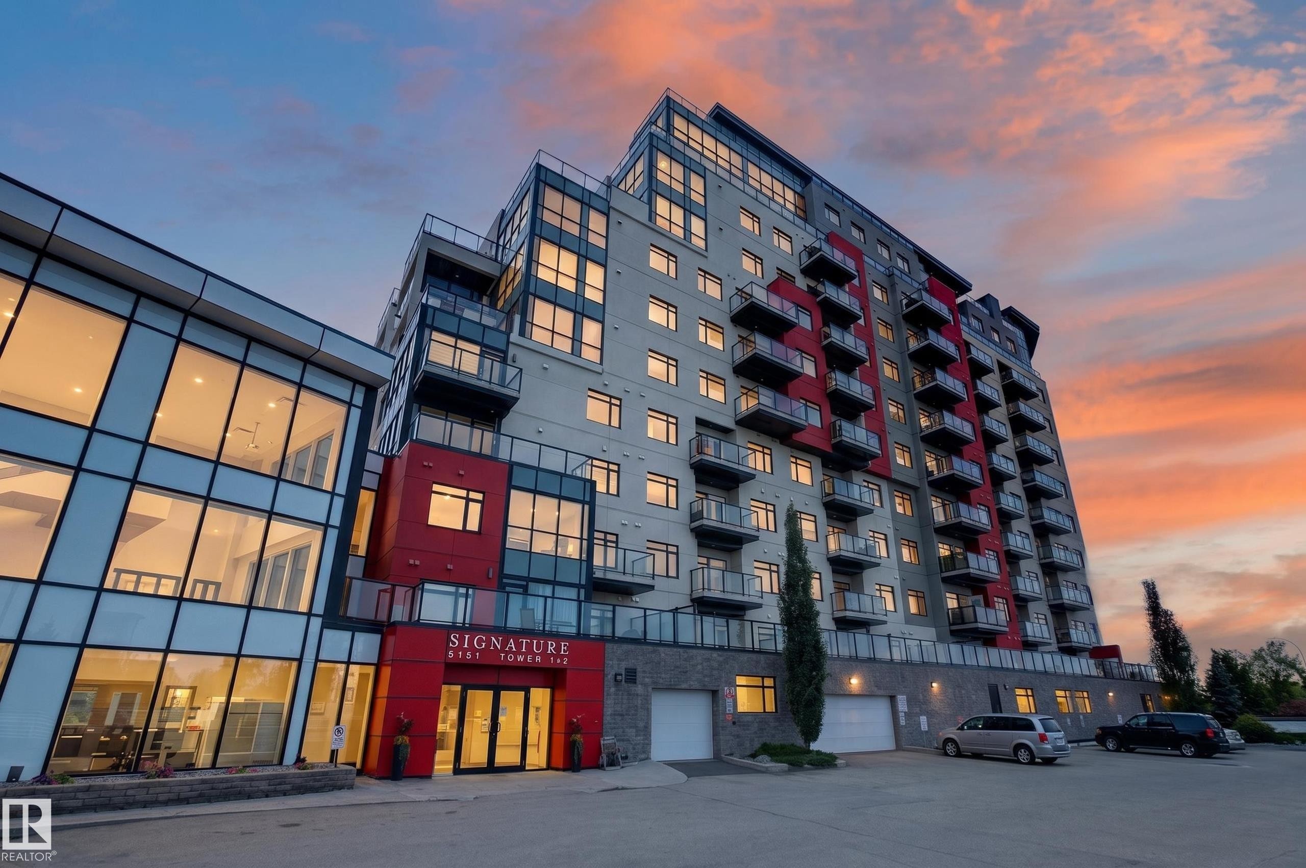 Modern multi-story building featuring extensive glazing and a striking red accent facade - 706 5151 Windermere Boulevard, Edmonton, AB