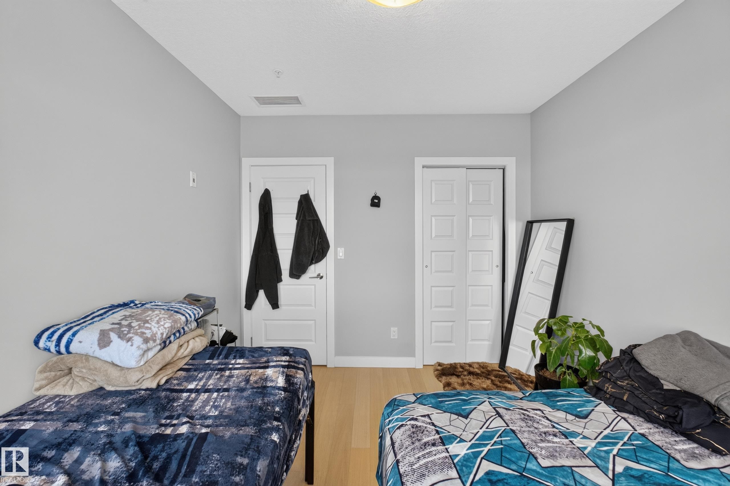 Light wood-finish flooring complements the neutral wall color - 706 5151 Windermere Boulevard, Edmonton, AB