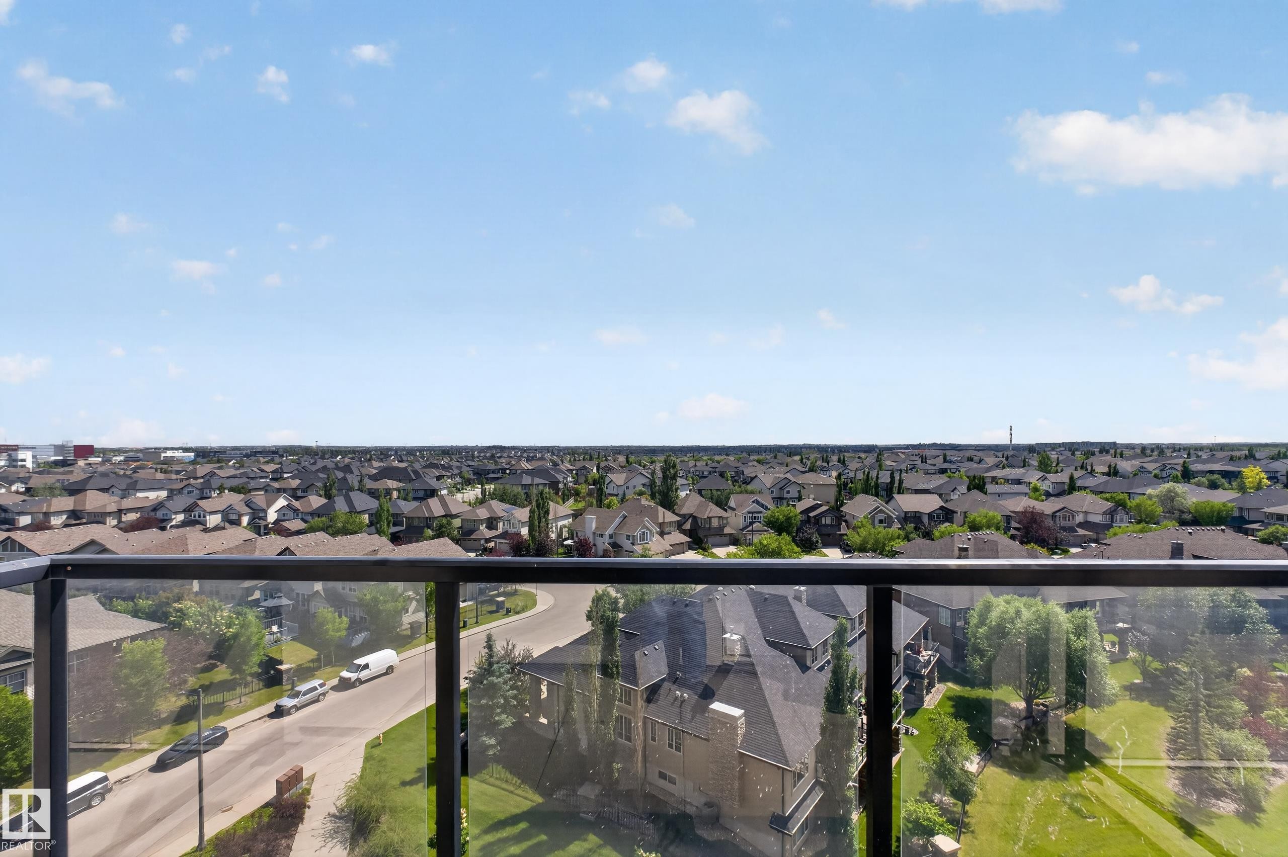 Expansive neighborhood scenery visible from a clear glass and dark metal railing - 706 5151 Windermere Boulevard, Edmonton, AB