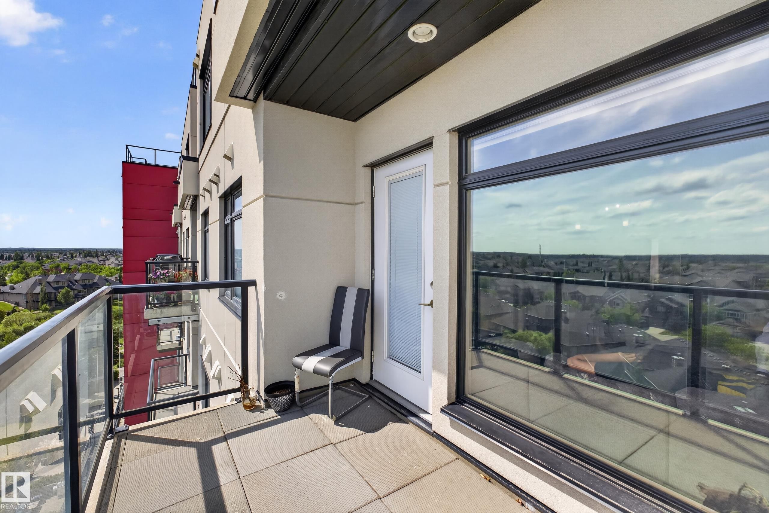 Balcony featuring square tile flooring, glass and metal railings, and a direct access door - 706 5151 Windermere Boulevard, Edmonton, AB