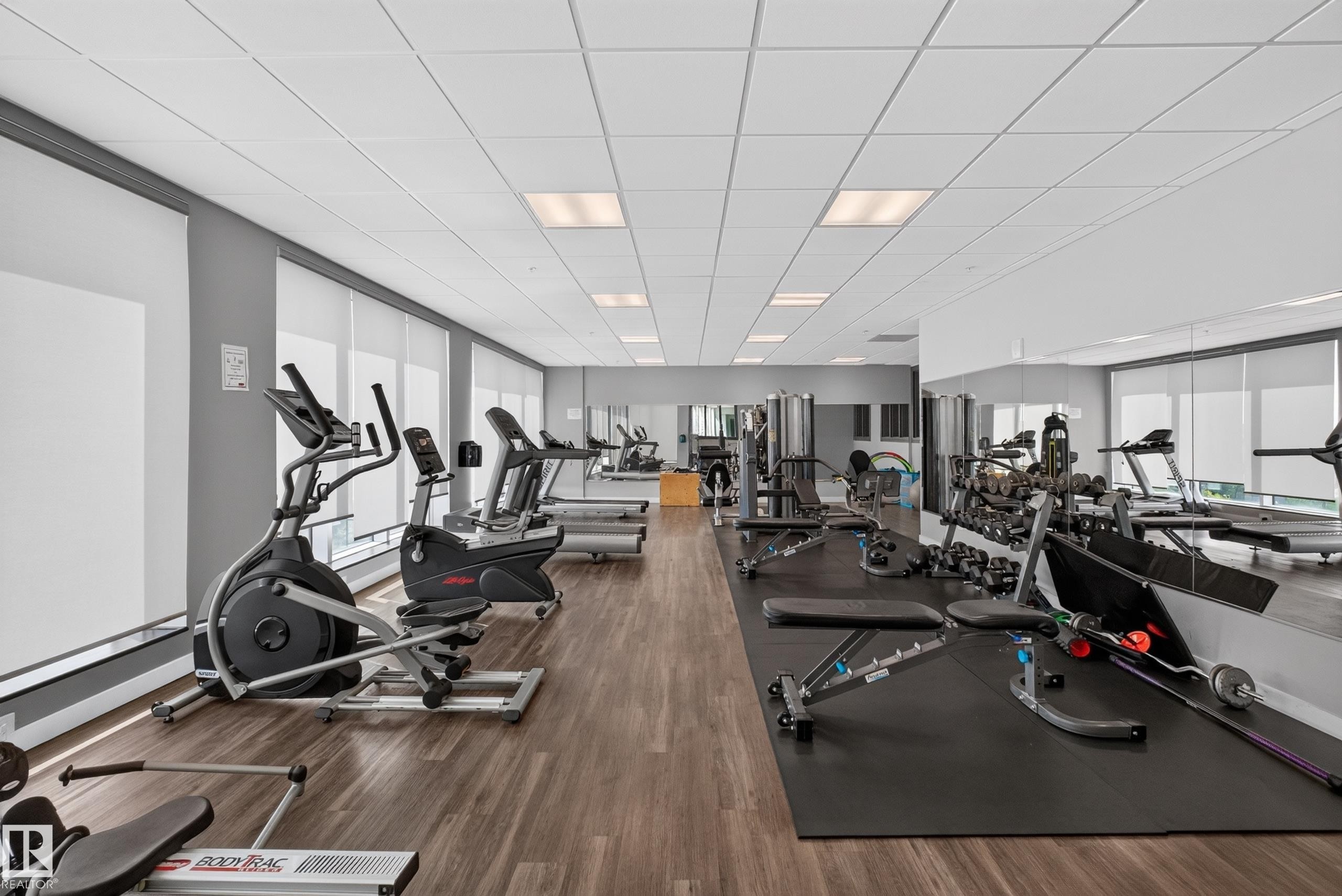 Dedicated fitness center featuring wood-finish flooring and extensive mirrored walls - 706 5151 Windermere Boulevard, Edmonton, AB