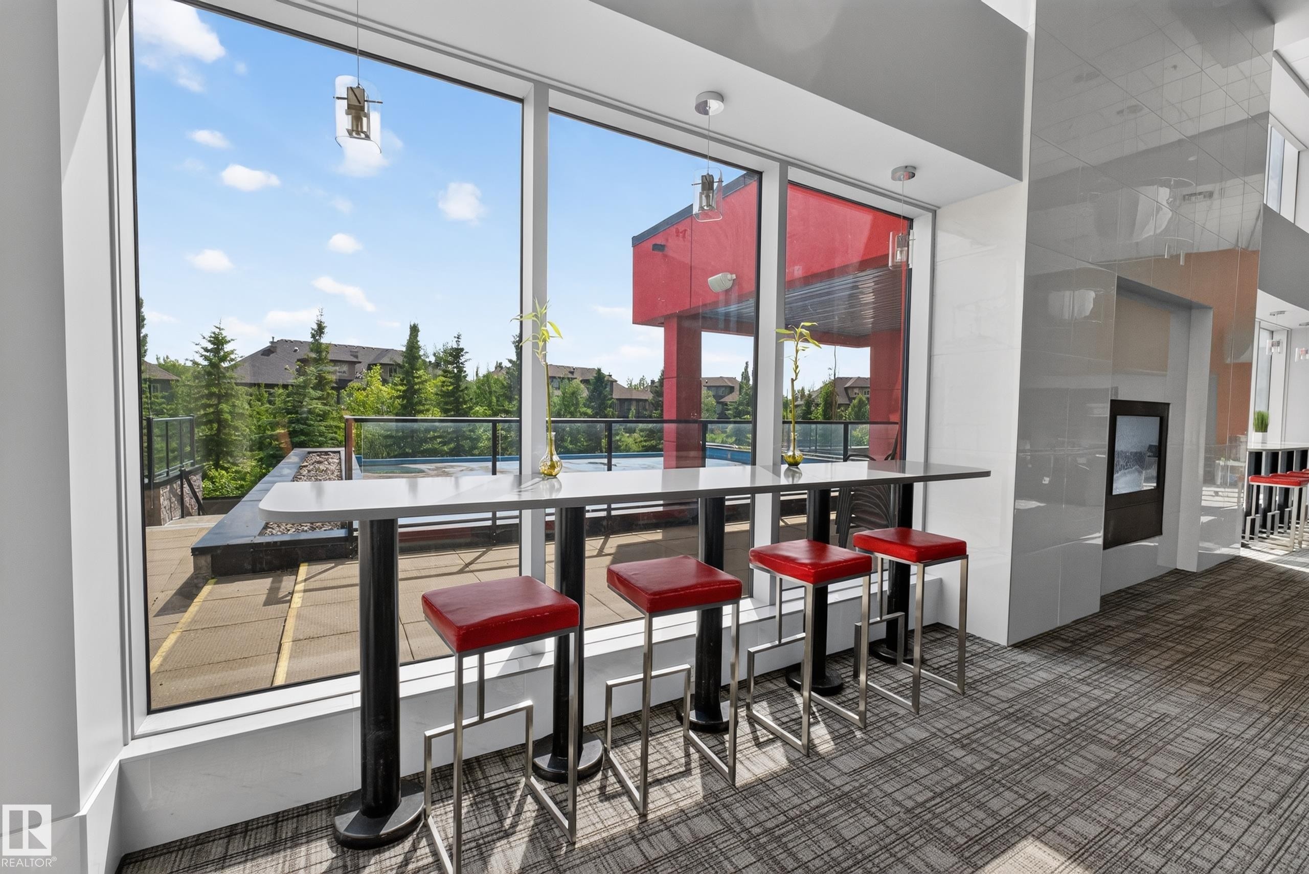 Floor-to-ceiling windows with a built-in counter and four bar stools - 706 5151 Windermere Boulevard, Edmonton, AB