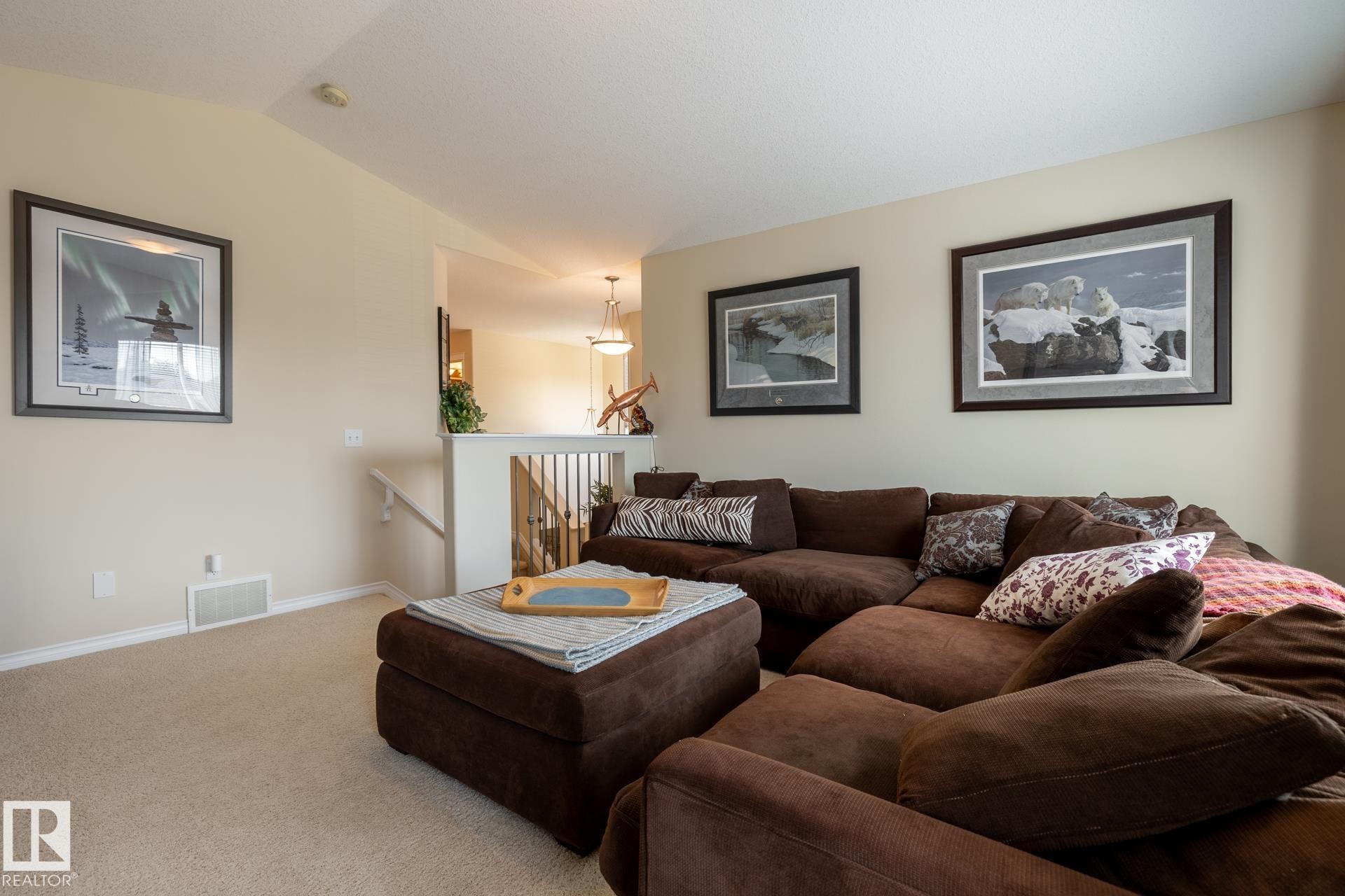 Carpeted living area featuring vaulted ceilings and neutral wall paint - 5820 7 Avenue Sw, Edmonton, AB - Indoor Photo Showing Living Room