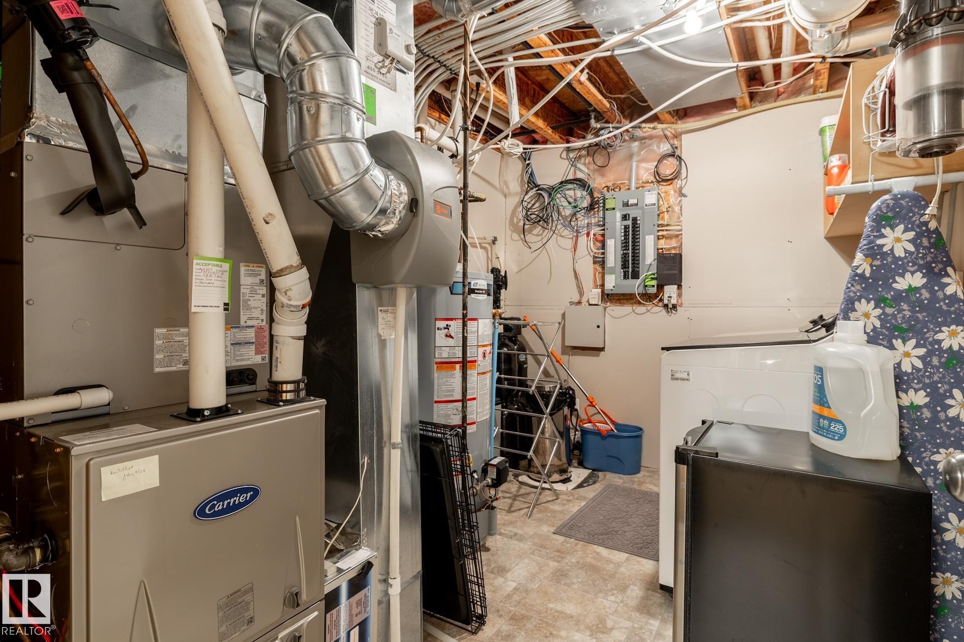 Utility area with a Carrier brand furnace, water heater, and electrical panel - 5820 7 Avenue Sw, Edmonton, AB - Indoor Photo Showing Basement
