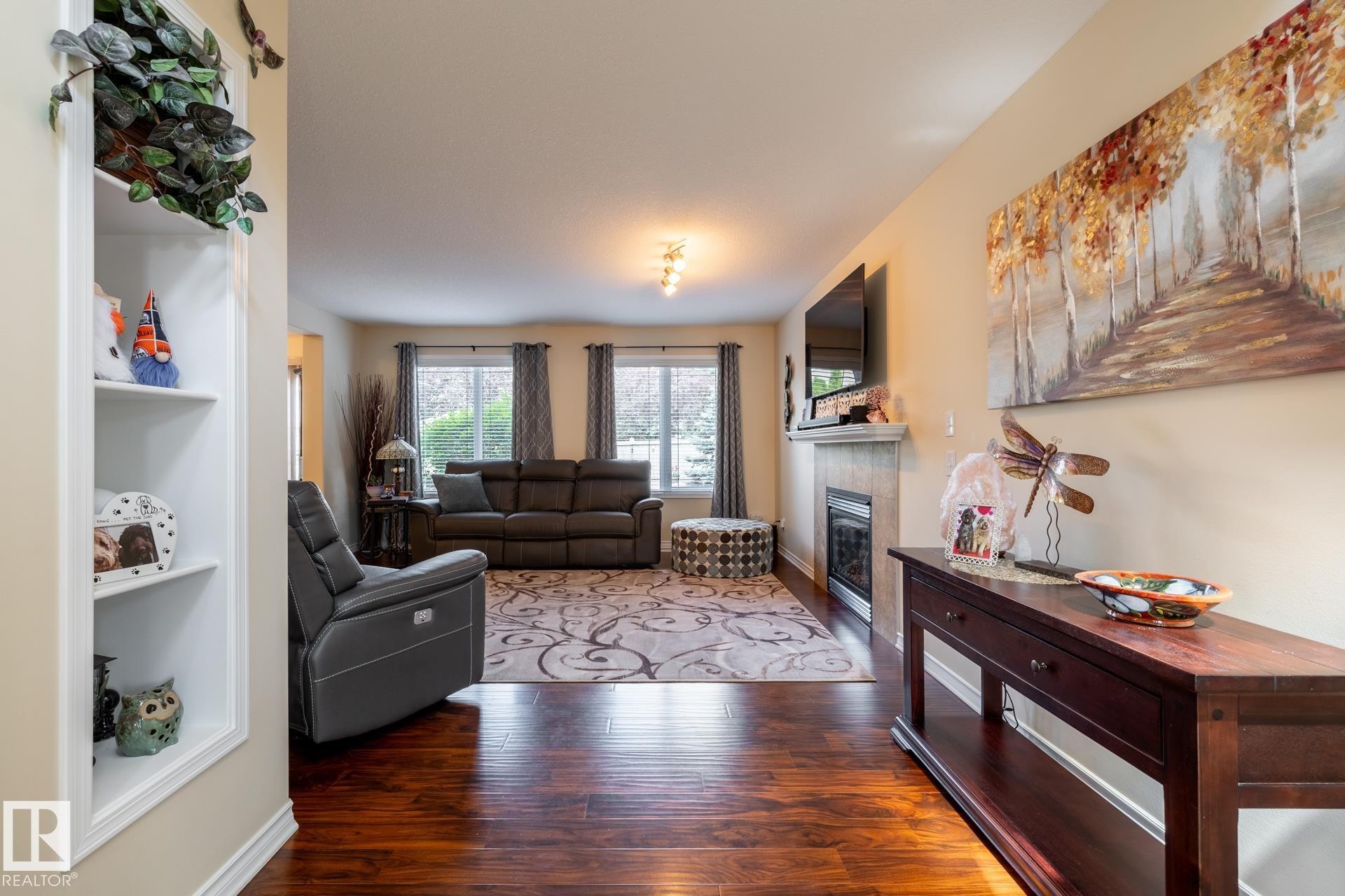 Hardwood-finish flooring extending into the main living space - 5820 7 Avenue Sw, Edmonton, AB - Indoor Photo Showing Other Room With Fireplace