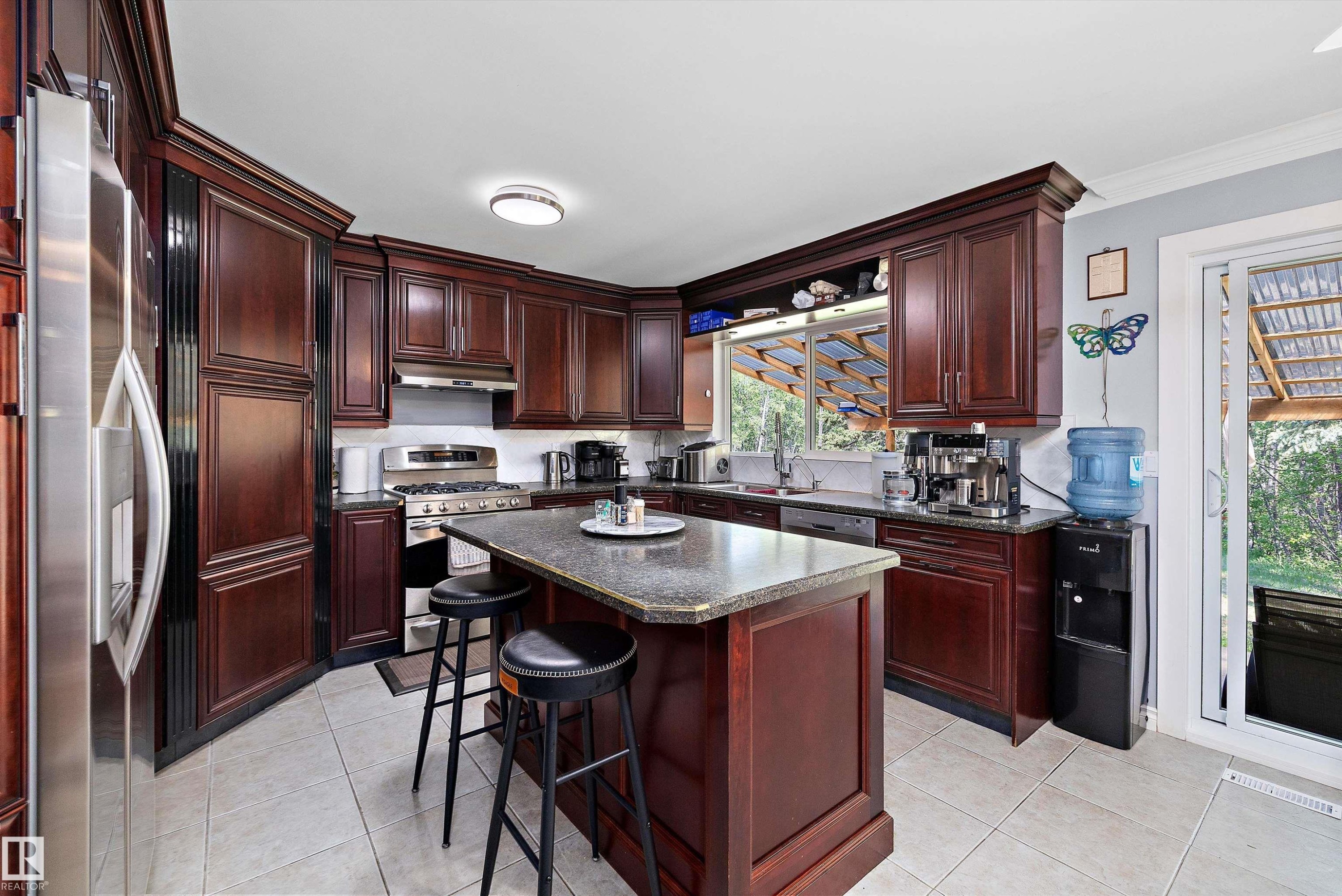 Kitchen featuring rich wood cabinetry, stainless steel appliances, a center island with seating, recessed lighting, and tile flooring - 53257 Rge Road 211, Rural Strathcona County, AB - Indoor Photo Showing Kitchen