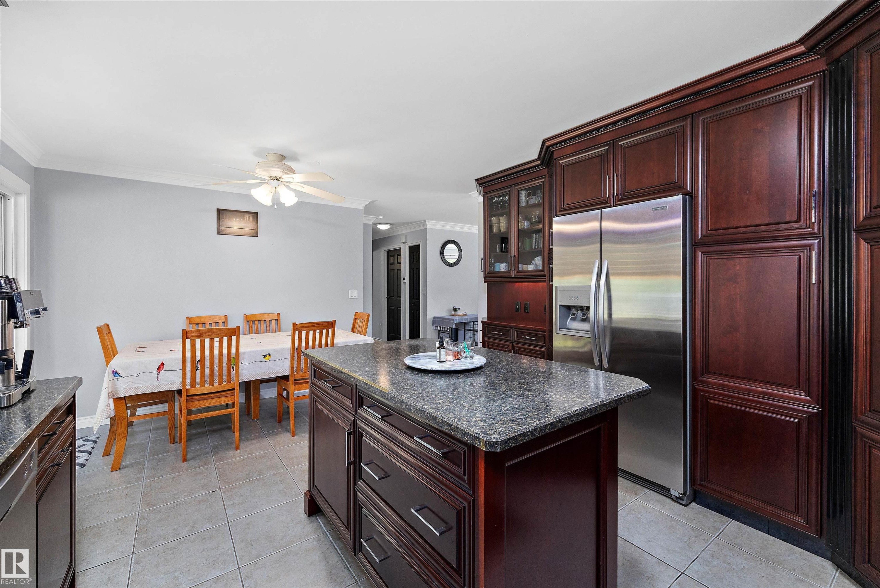 Kitchen featuring dark wood cabinetry, a central island with a stone-finish countertop, a stainless steel refrigerator, and recessed lighting - 53257 Rge Road 211, Rural Strathcona County, AB - Indoor Photo Showing Kitchen