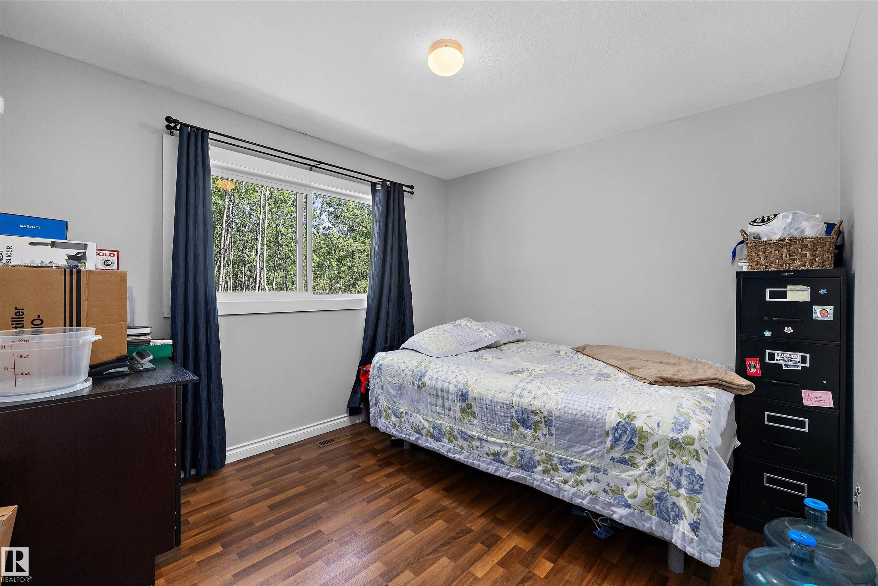 Room featuring wood-finish flooring, light grey painted walls, and a ceiling-mounted light fixture - 53257 Rge Road 211, Rural Strathcona County, AB - Indoor Photo Showing Bedroom