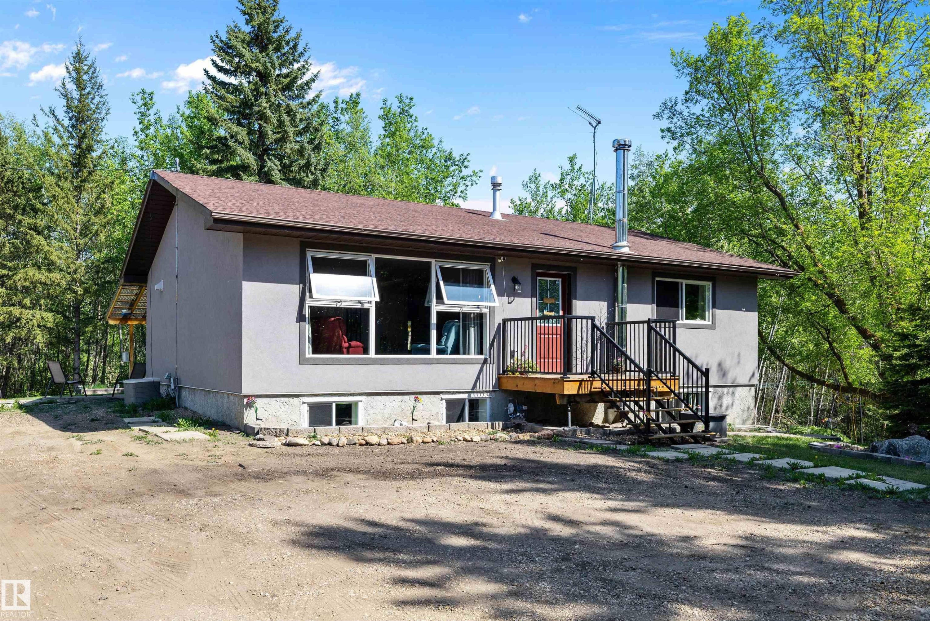 Ranch-style residence featuring a gray exterior, brown asphalt shingle roof, and multiple large windows - 53257 Rge Road 211, Rural Strathcona County, AB - Outdoor
