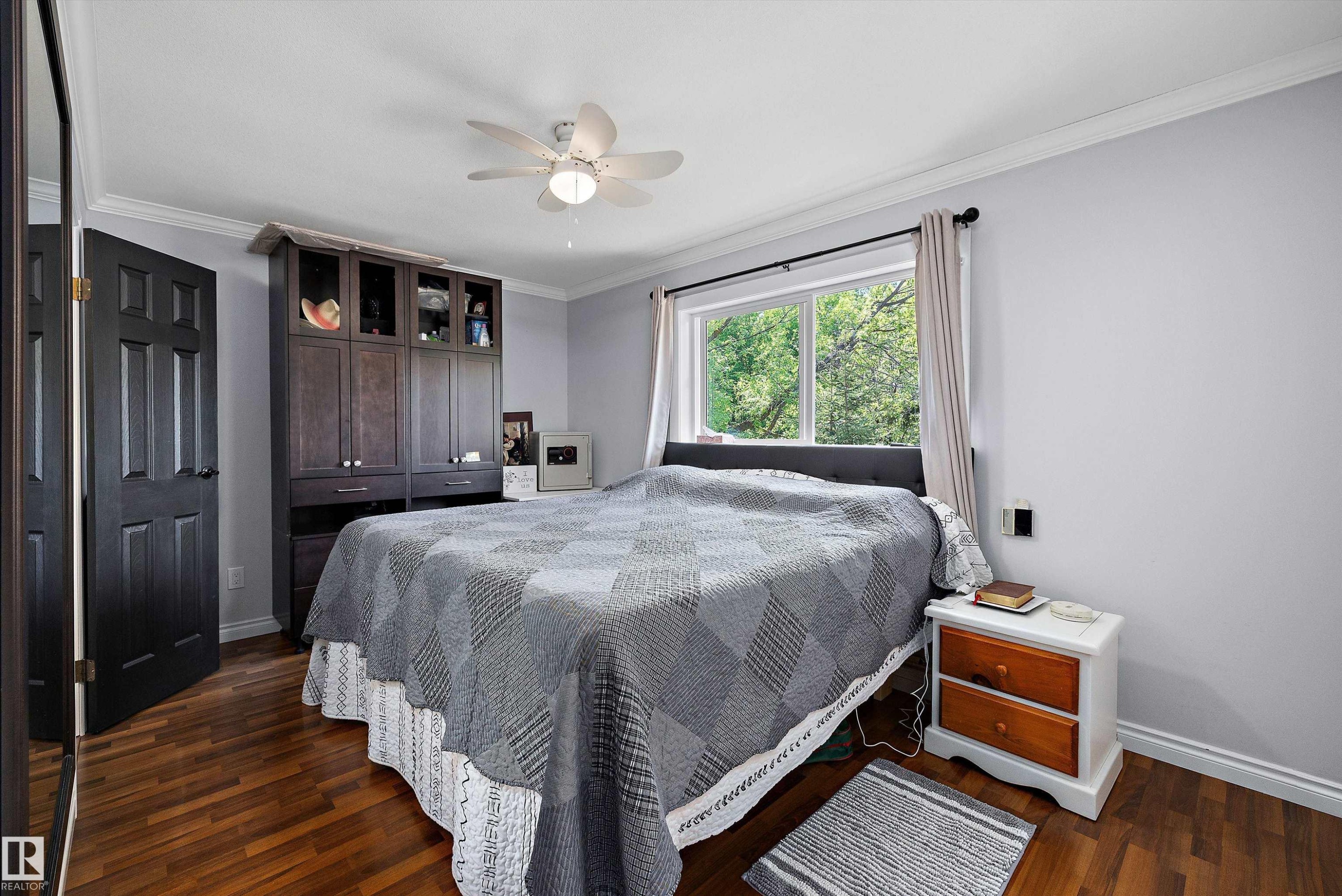Bedroom featuring wood-finish flooring, a ceiling fan with integrated lighting, and crown molding - 53257 Rge Road 211, Rural Strathcona County, AB - Indoor Photo Showing Bedroom