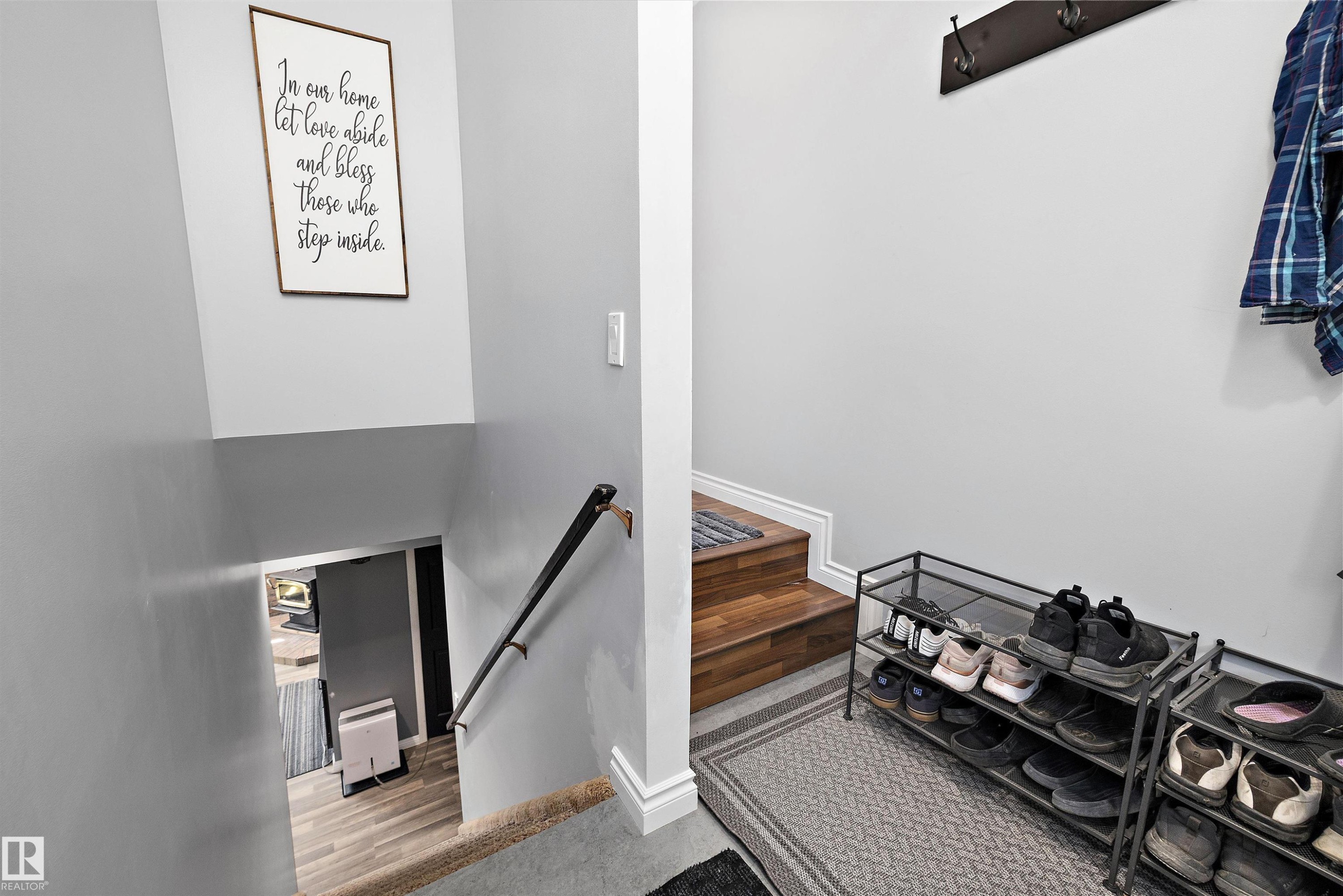 Split-level entryway featuring wood-finish stairs, a metal handrail, and light gray wall paint - 53257 Rge Road 211, Rural Strathcona County, AB - Indoor Photo Showing Other Room