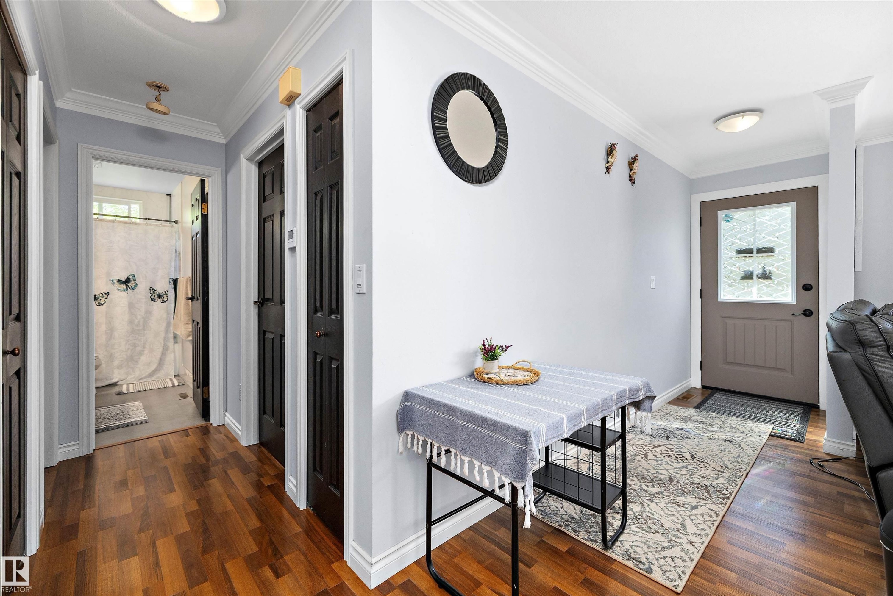 Entryway featuring wood-finish flooring, light gray walls, white crown molding, and a front door with a decorative glass insert - 53257 Rge Road 211, Rural Strathcona County, AB - Indoor Photo Showing Other Room
