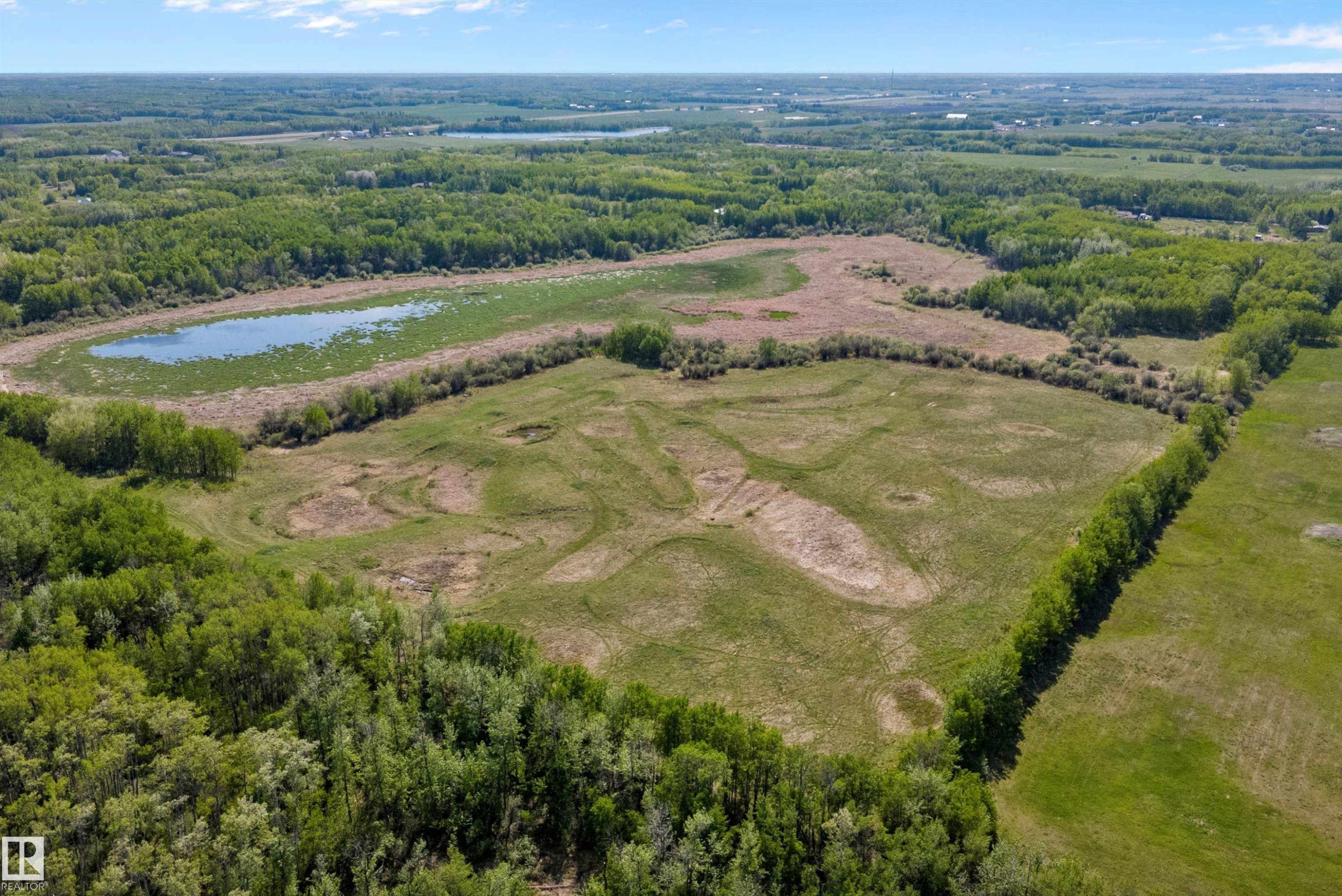 Expansive land parcel with a large pond, surrounded by mature trees and open fields - 53257 Rge Road 211, Rural Strathcona County, AB - Outdoor With View