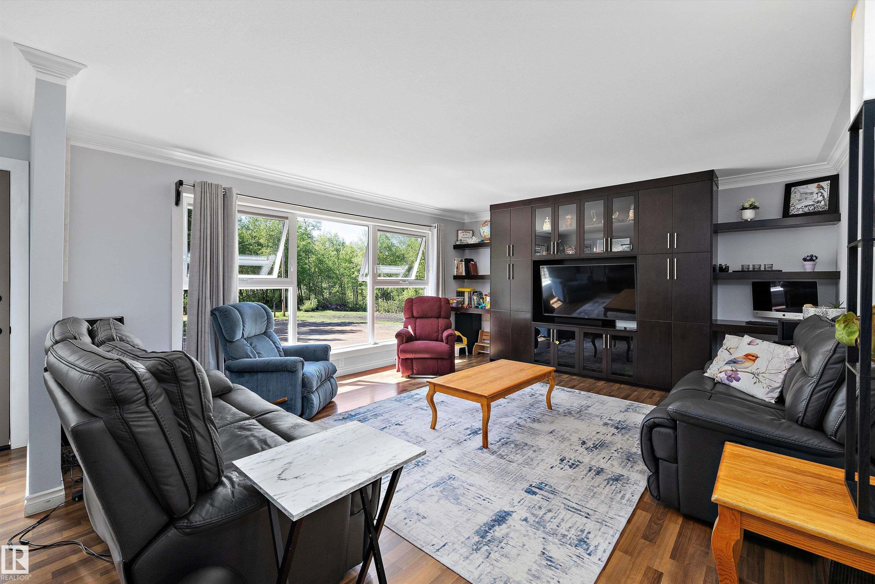 Spacious living area featuring expansive windows, wood-finish flooring, and crown molding - 53257 Rge Road 211, Rural Strathcona County, AB - Indoor Photo Showing Living Room