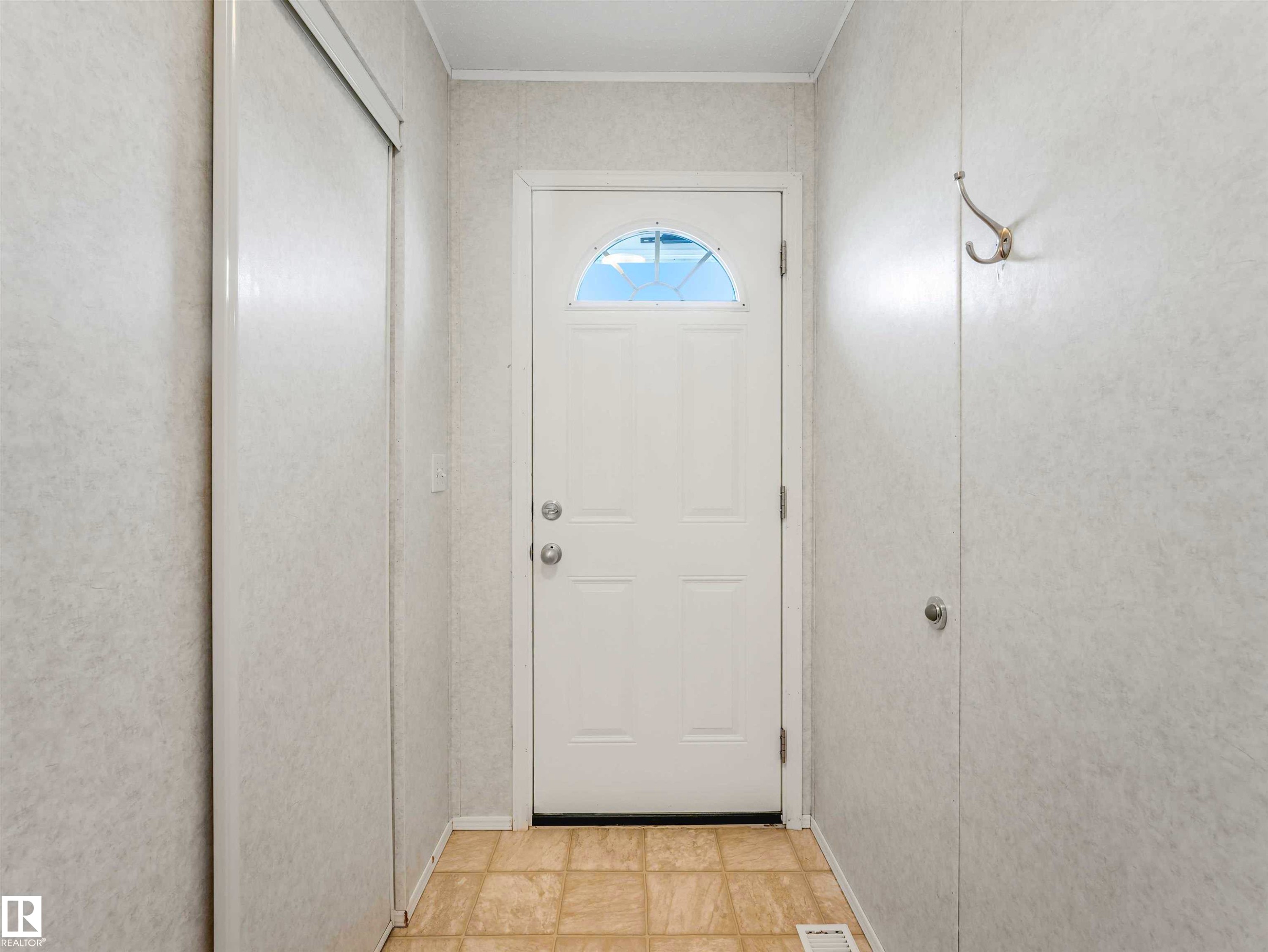 Entryway featuring a white door with an arched window, light-toned tiled flooring, and a built-in coat hook - 57016 Range Road 13, Rural Barrhead County, AB - Indoor Photo Showing Other Room