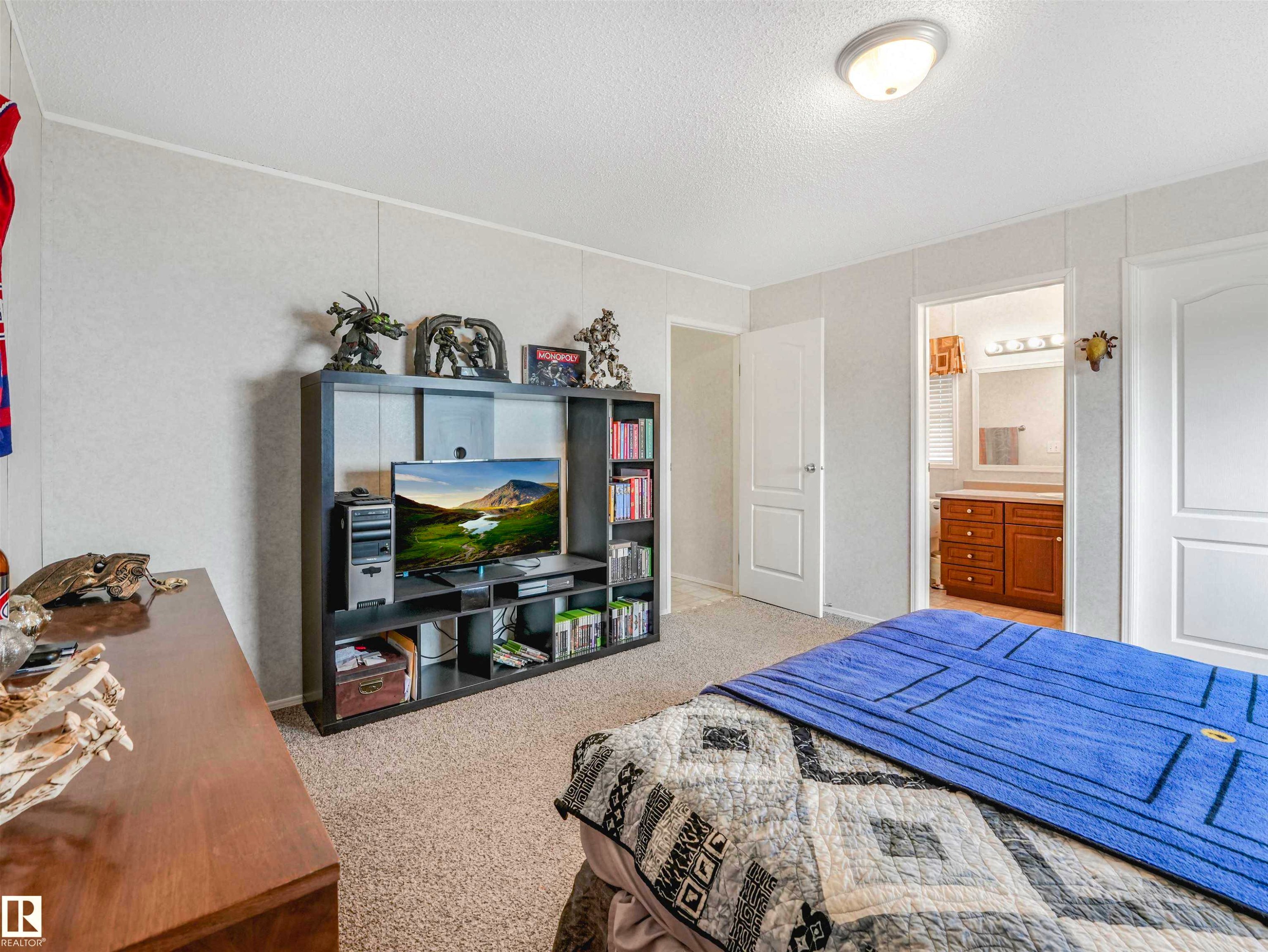 Carpeted room featuring light-toned walls, a flush-mount ceiling light, and white paneled doors - 57016 Range Road 13, Rural Barrhead County, AB - Indoor Photo Showing Bedroom