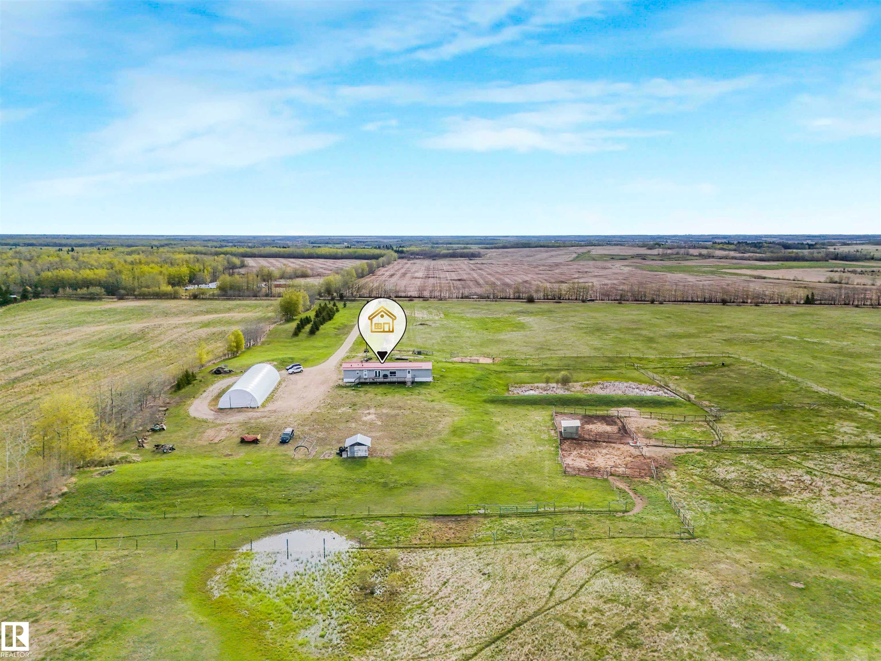 Expansive rural property featuring a primary residence with a surrounding lawn, a large greenhouse structure, a storage shed, and fenced pasture areas - 57016 Range Road 13, Rural Barrhead County, AB - Outdoor With View