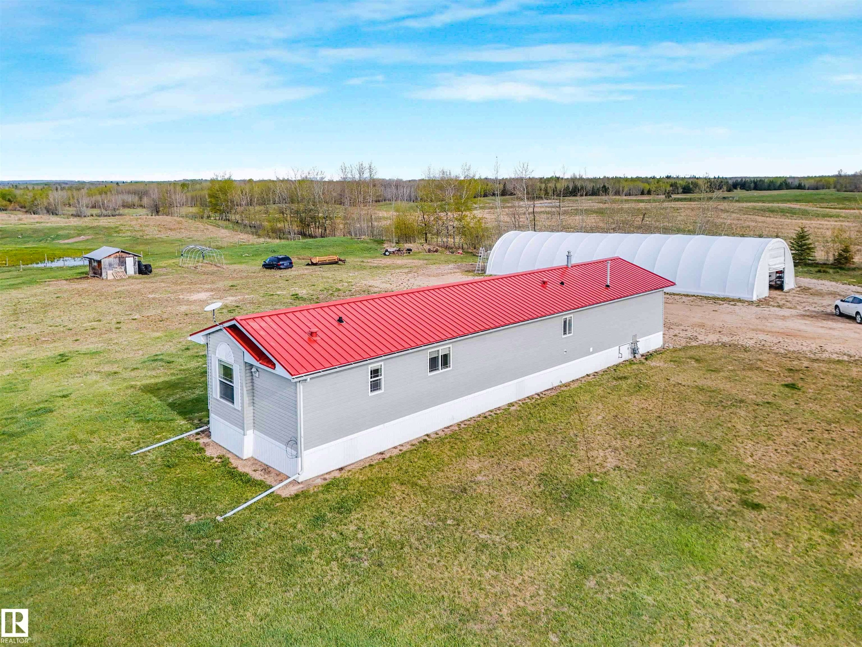 Single-story structure featuring a red metal roof and light grey siding - 57016 Range Road 13, Rural Barrhead County, AB - Outdoor