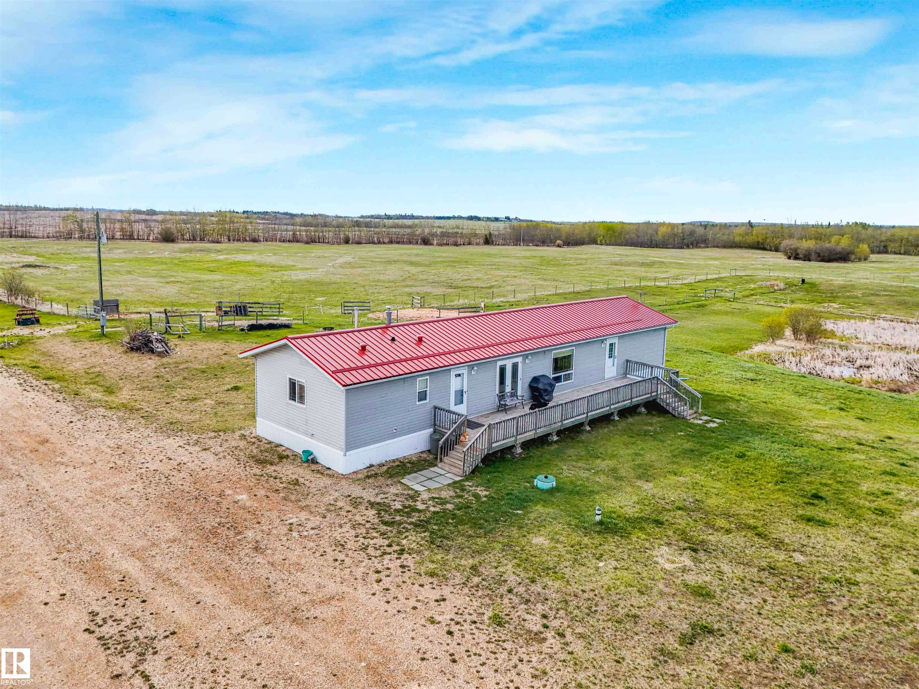 Single-story residence featuring light gray siding and a red metal roof - 57016 Range Road 13, Rural Barrhead County, AB - Outdoor With View