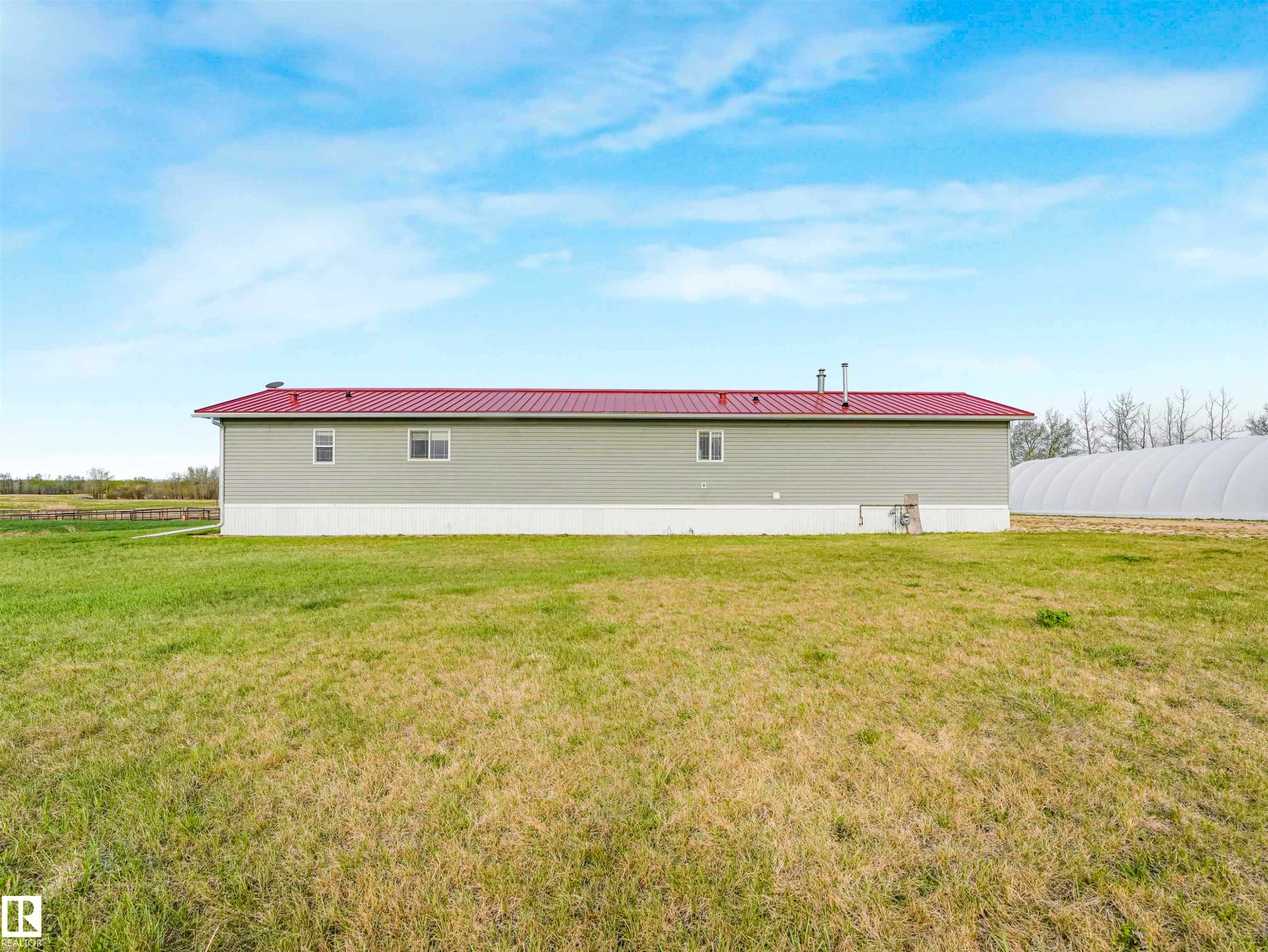 Agricultural building with a red metal roof, light green siding, and multiple windows - 57016 Range Road 13, Rural Barrhead County, AB - Outdoor