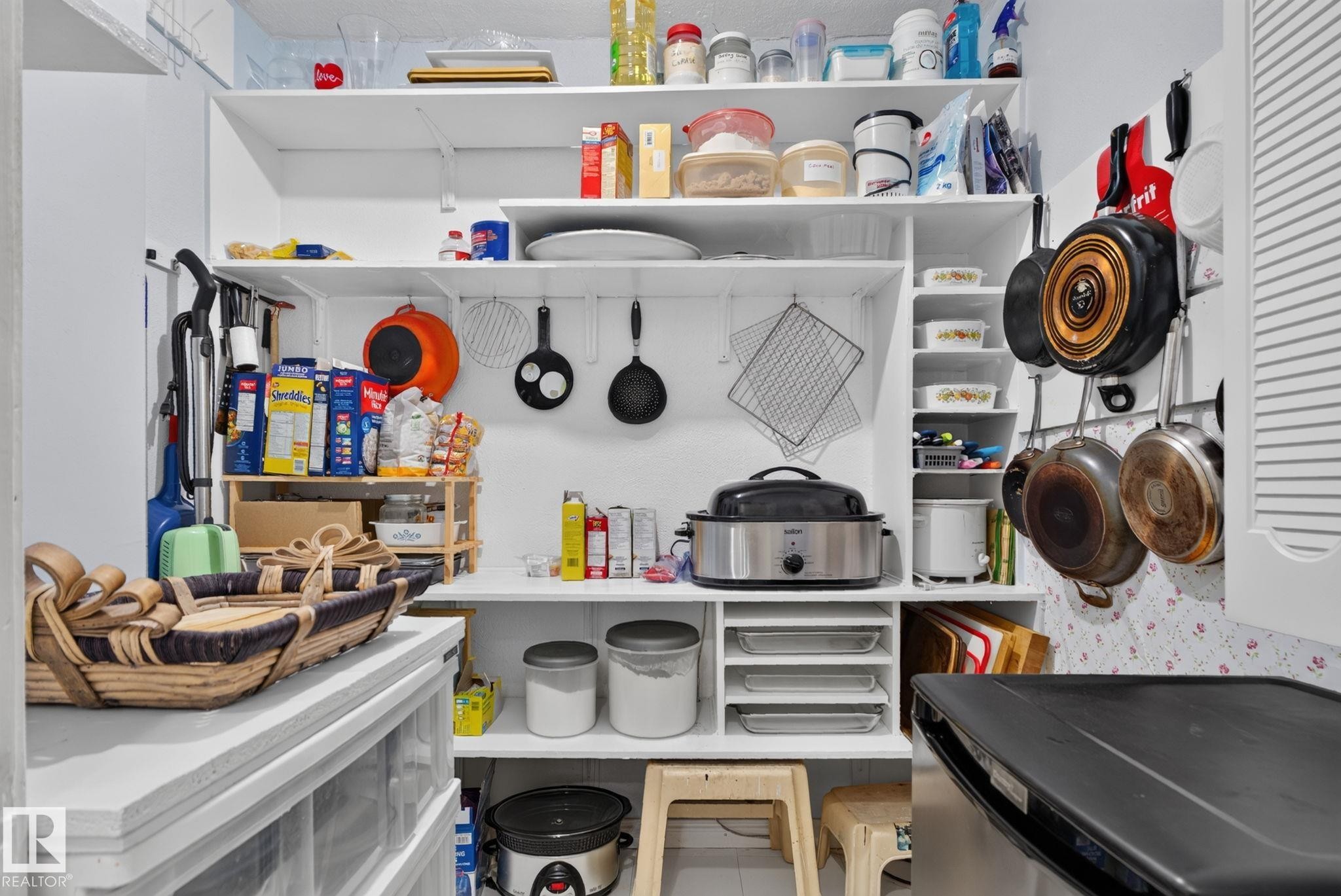 Organized pantry featuring multiple open shelving units and integrated vertical storage - 12703 122 Street Nw, Edmonton, AB