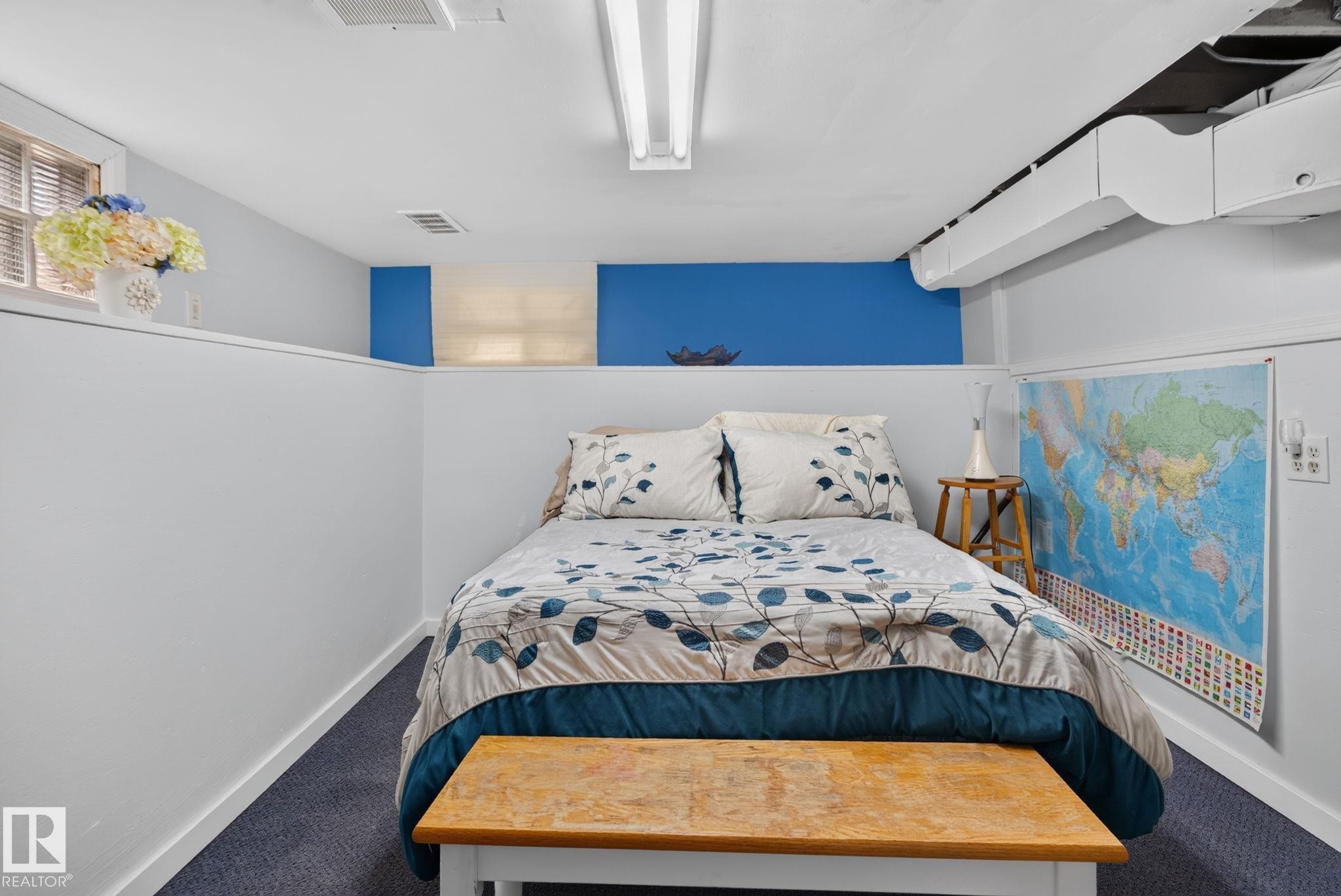 Room featuring a drop ceiling with fluorescent lighting, light gray walls with a vibrant blue accent band, and a window with blinds - 12703 122 Street Nw, Edmonton, AB