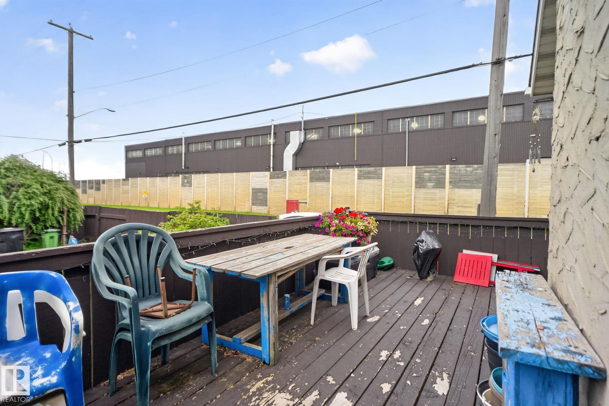 Wooden deck area featuring a dark stained surface and a low railing - 12703 122 Street Nw, Edmonton, AB