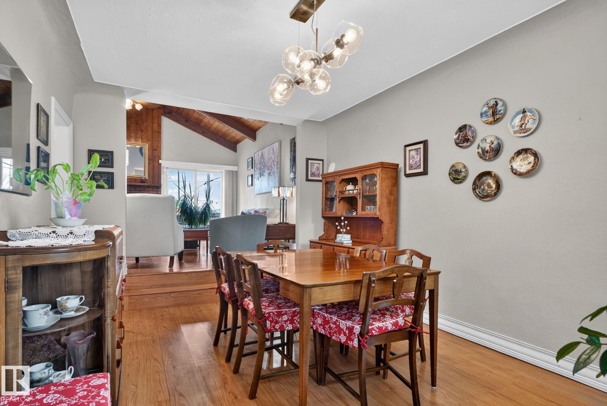 Dining area with wood-finish flooring, a contemporary chandelier, and light gray walls - 12703 122 Street Nw, Edmonton, AB