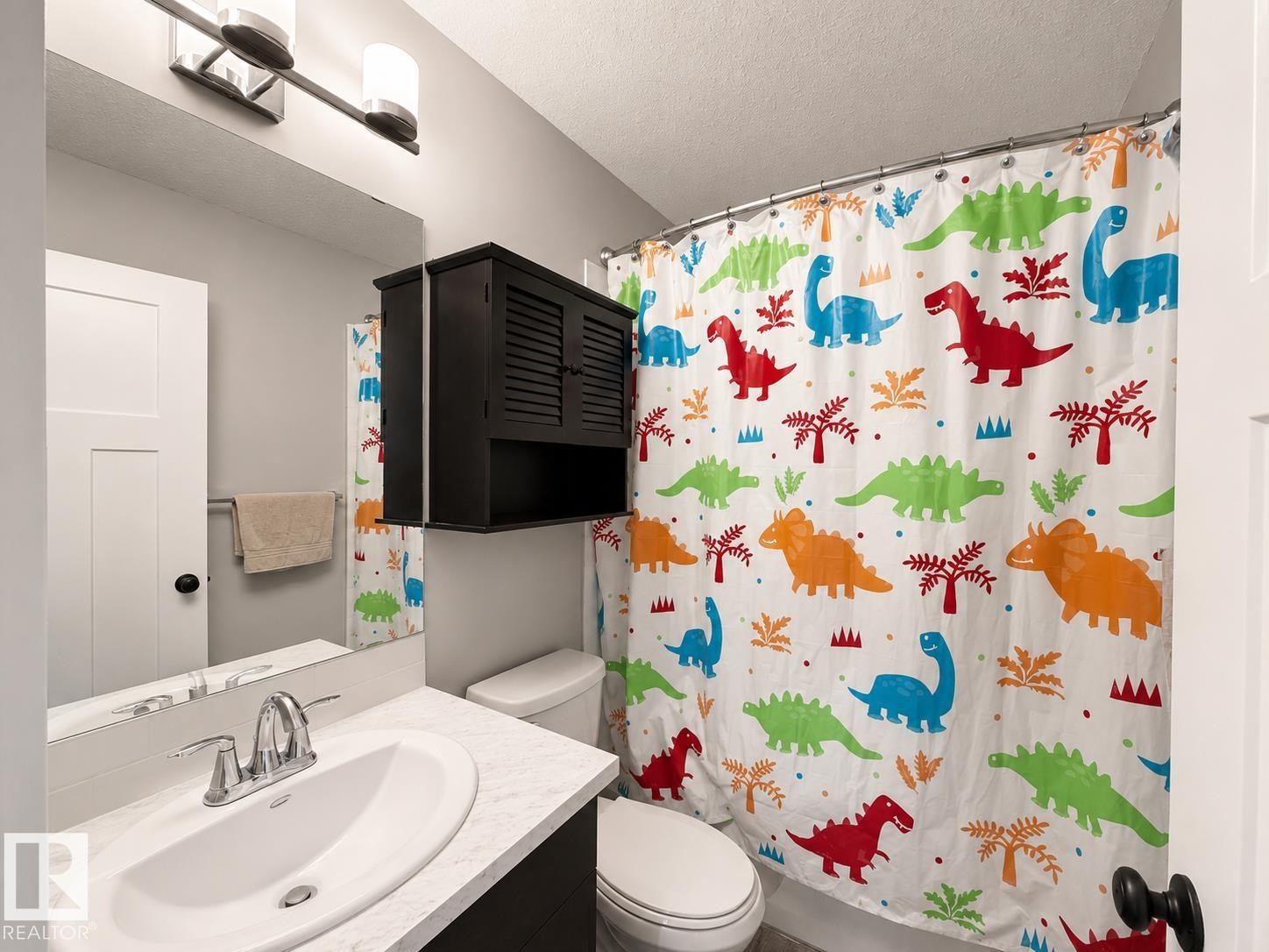 Bathroom featuring a white vanity with a single basin, chrome faucet, and integrated mirror - 187 Radcliffe Wynd, Fort Saskatchewan, AB - Indoor Photo Showing Bathroom