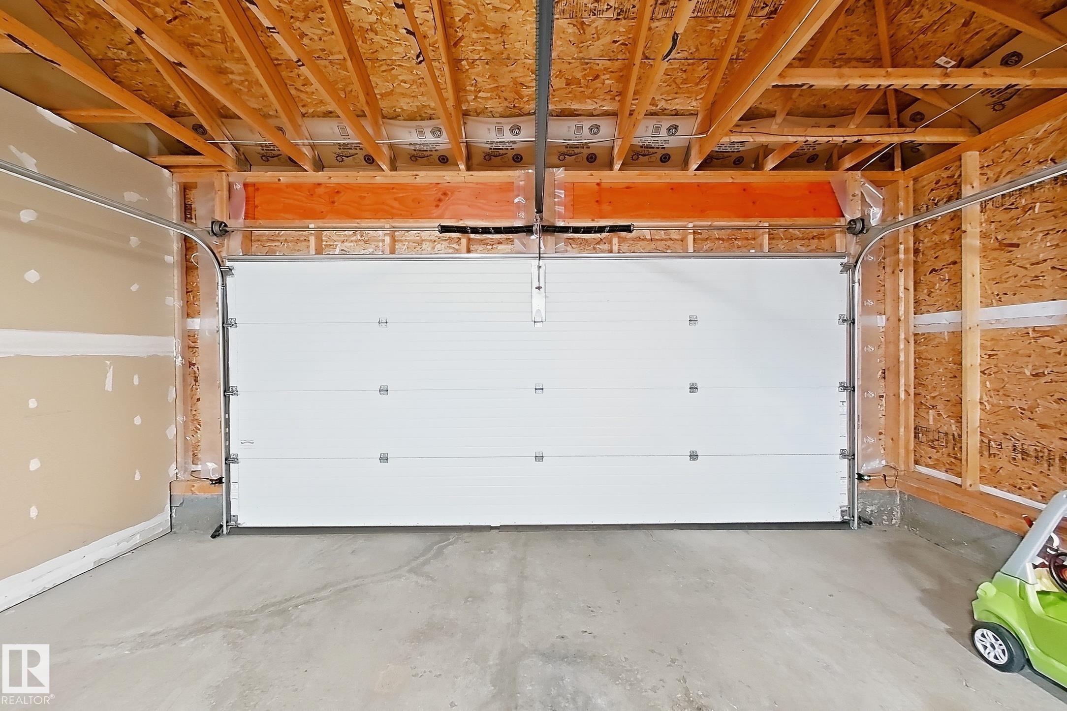Garage space featuring a white sectional overhead door - 187 Radcliffe Wynd, Fort Saskatchewan, AB - Indoor Photo Showing Garage