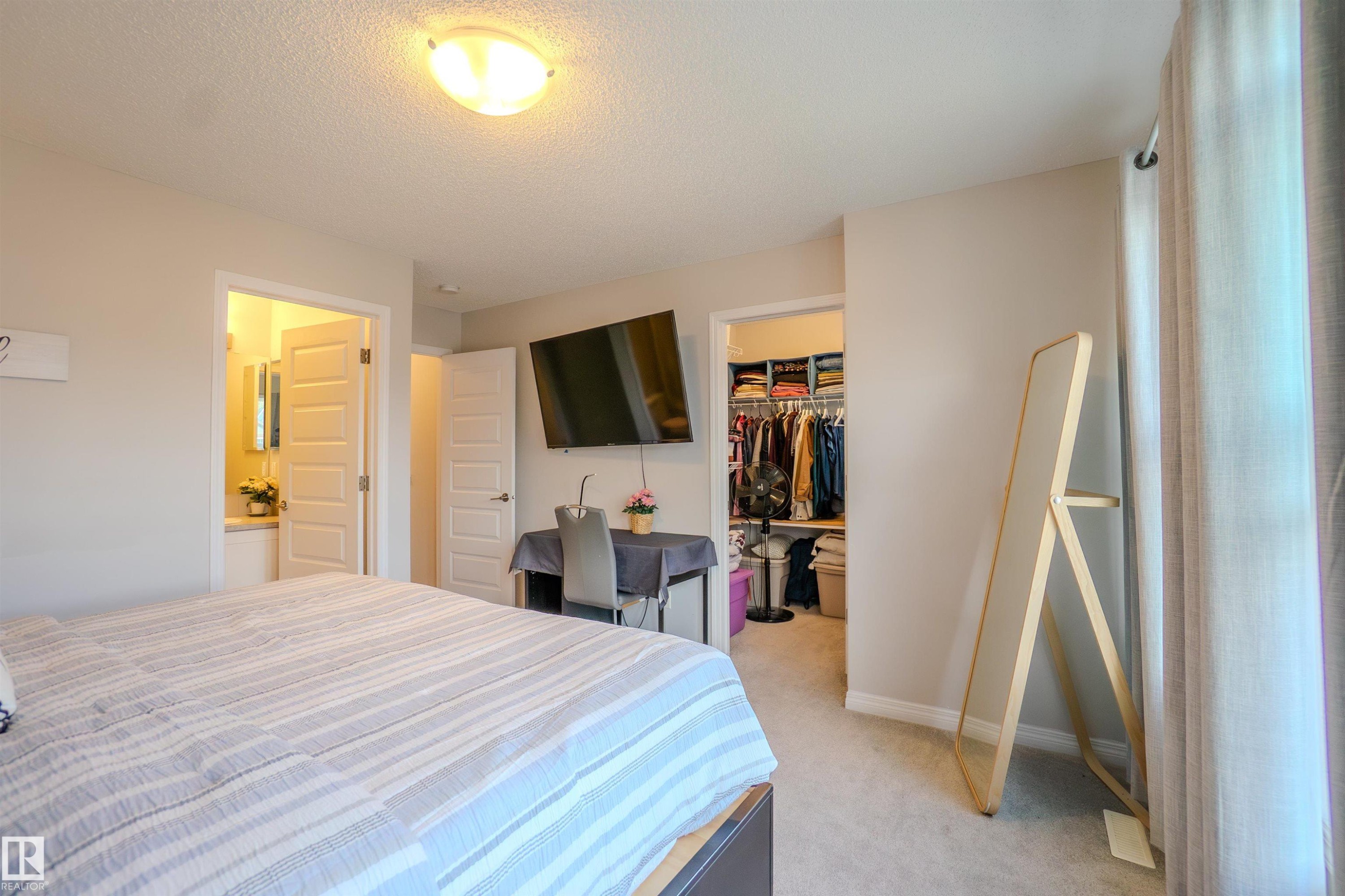 Neutral-toned room featuring a ceiling-mounted light fixture, light gray carpeting, and white baseboards - 1766 Dumont Crescent Sw, Edmonton, AB - Indoor Photo Showing Bedroom