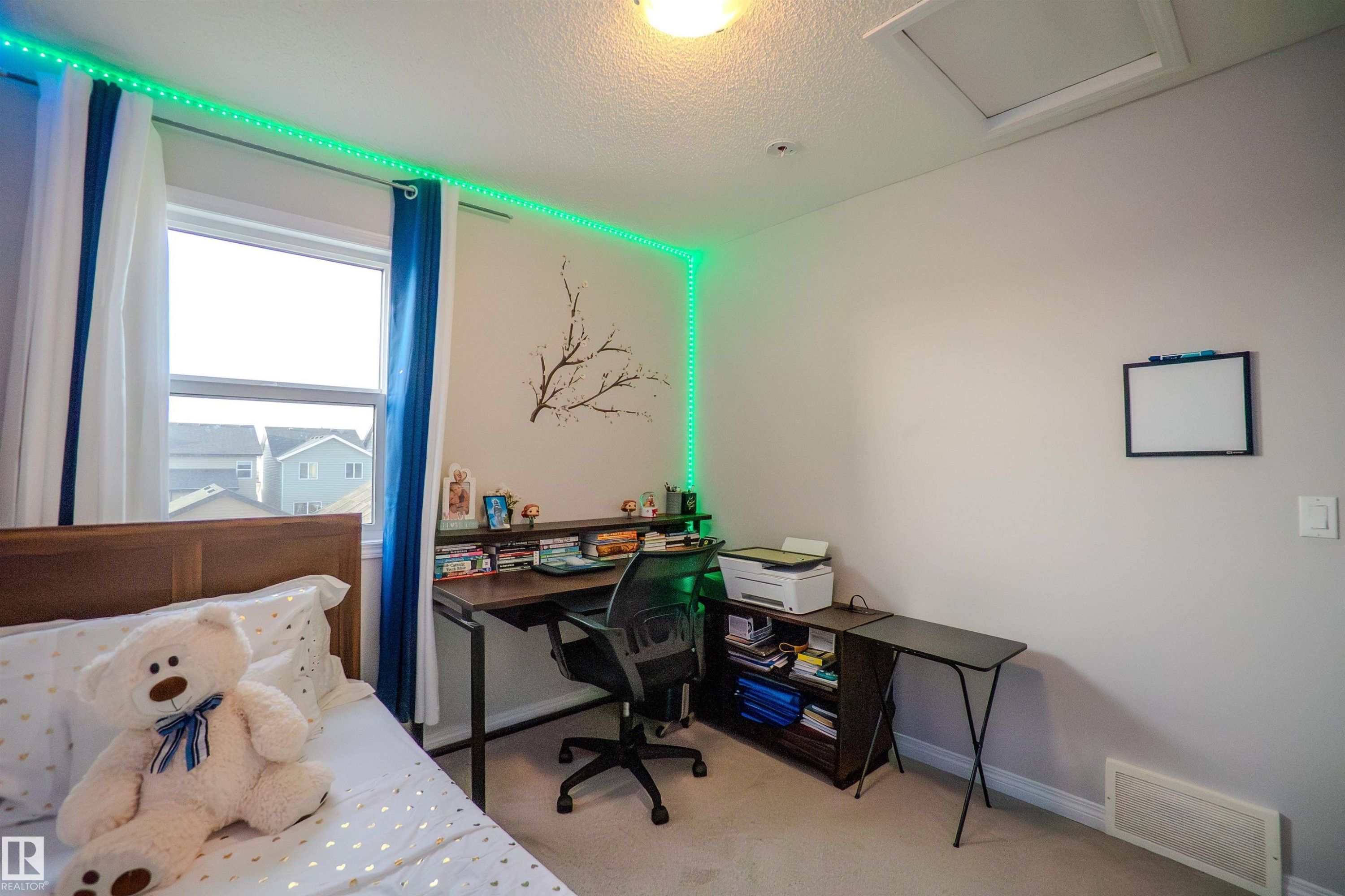 Carpeted room with a single window featuring white and blue curtains - 1766 Dumont Crescent Sw, Edmonton, AB - Indoor