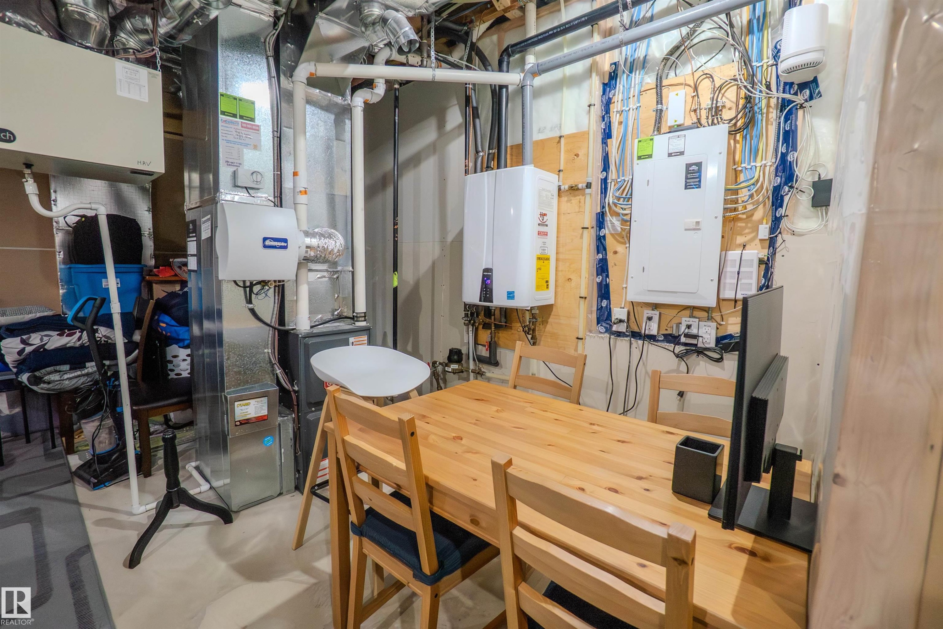 Utility room featuring a furnace, water heater, electrical panel, and exposed ductwork - 1766 Dumont Crescent Sw, Edmonton, AB - Indoor Photo Showing Basement