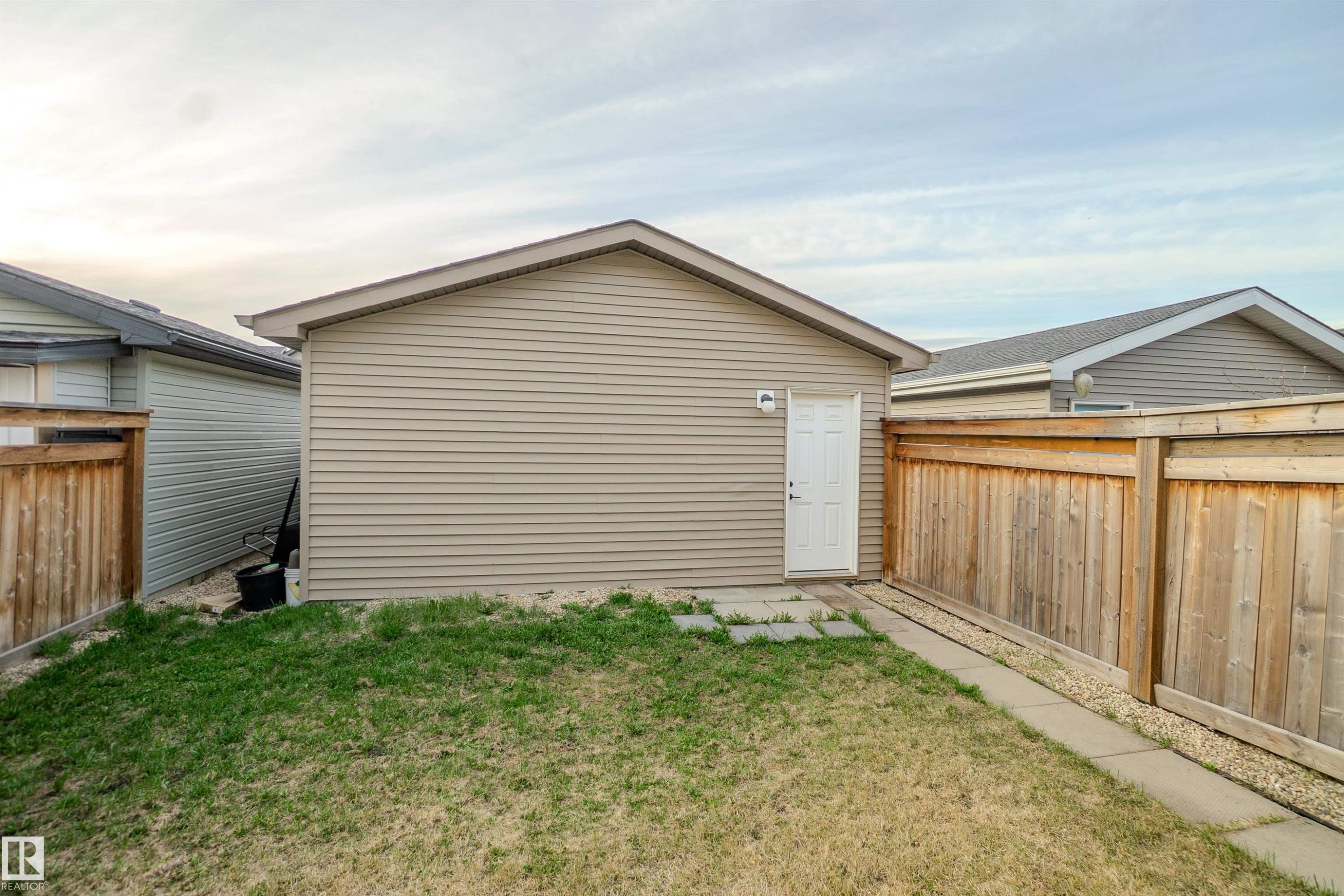 Detached garage featuring horizontal siding and a white access door - 1766 Dumont Crescent Sw, Edmonton, AB - Outdoor With Exterior
