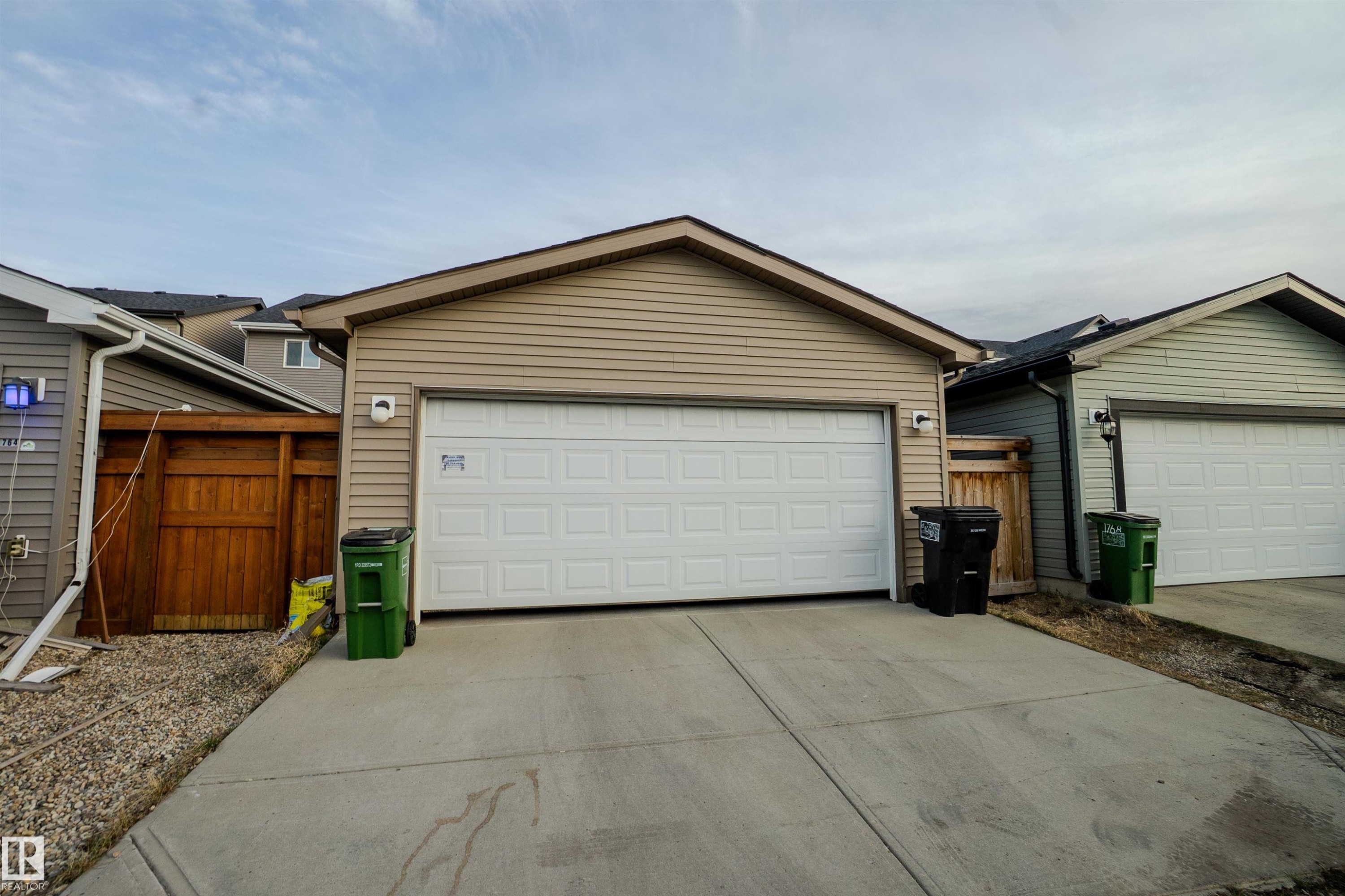 Detached garage featuring panel garage door, siding exterior, and concrete driveway - 1766 Dumont Crescent Sw, Edmonton, AB - Outdoor