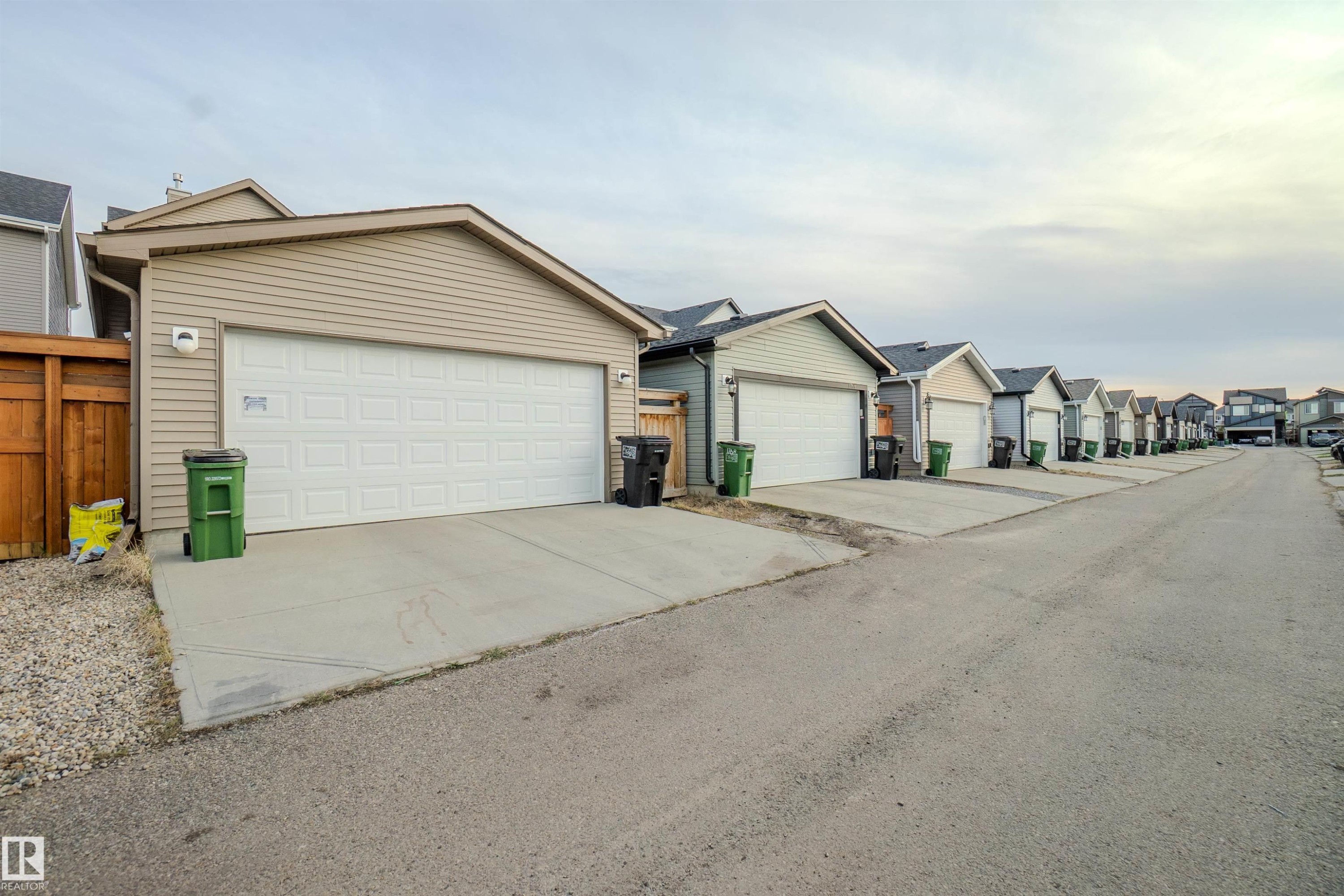 Detached garage featuring panel siding and a wood privacy fence - 1766 Dumont Crescent Sw, Edmonton, AB - Outdoor