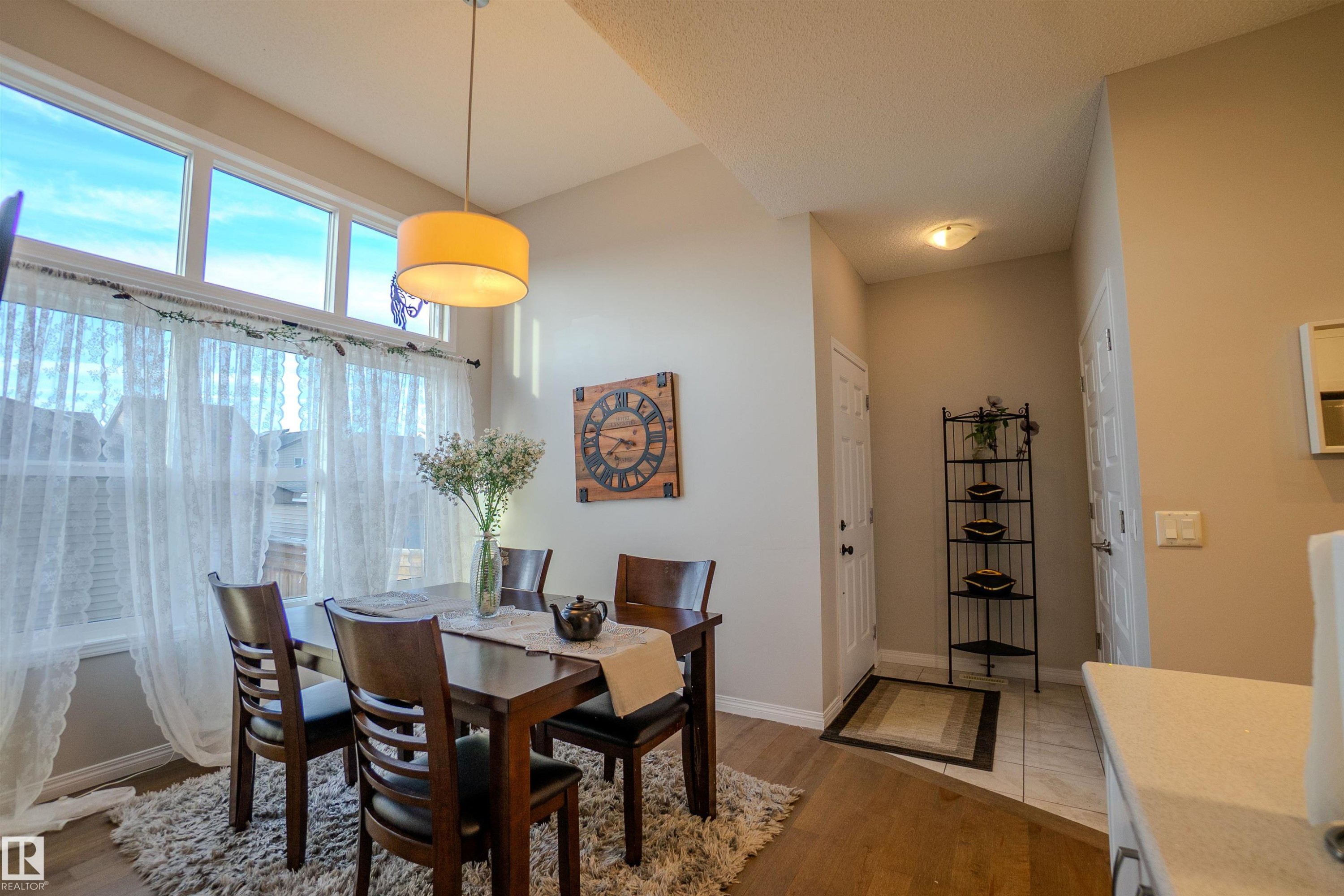 Dining area featuring wood-finish flooring and a contemporary pendant light fixture - 1766 Dumont Crescent Sw, Edmonton, AB - Indoor Photo Showing Dining Room