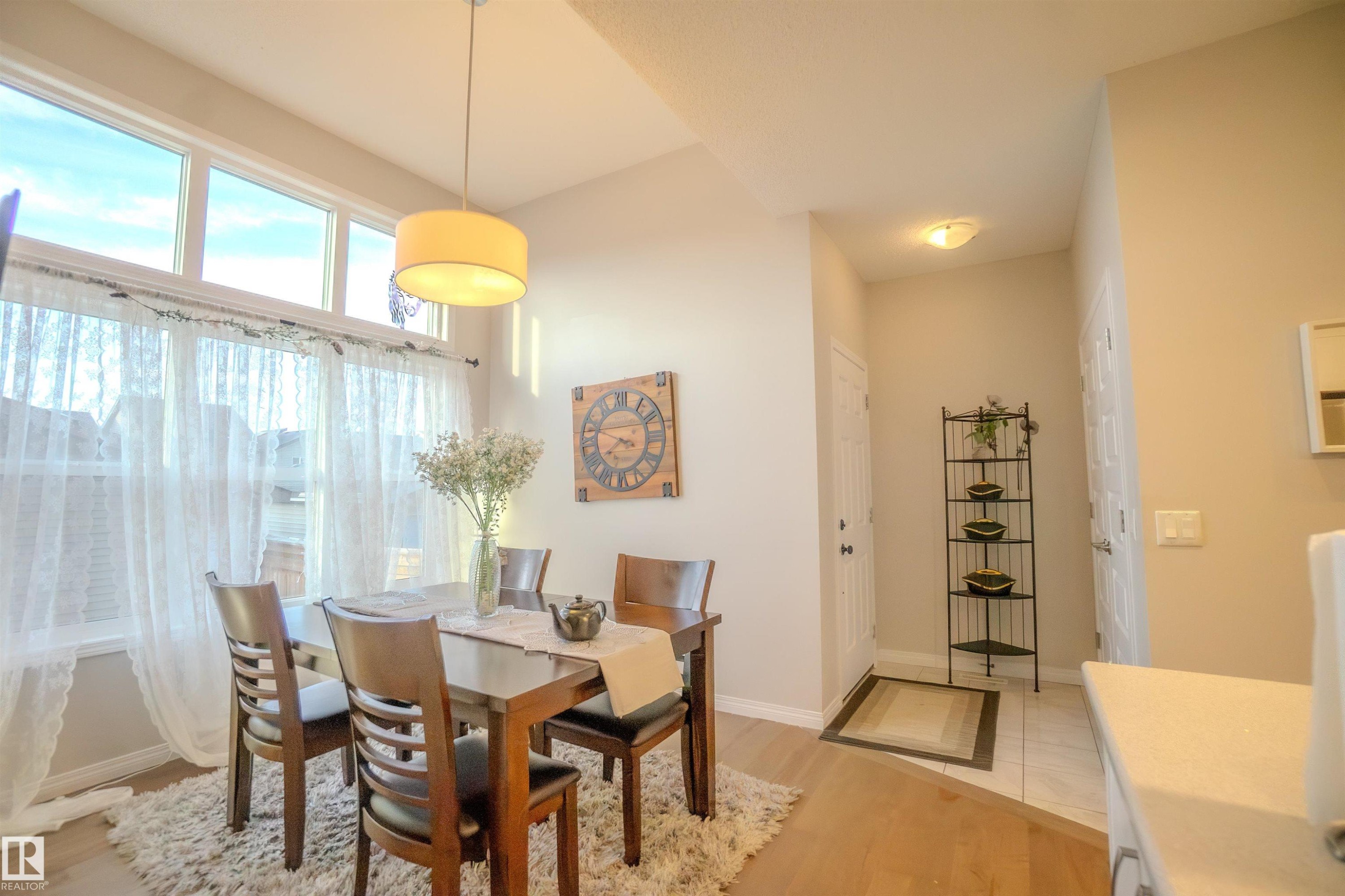 Dining area with vaulted ceiling and a drum pendant light fixture - 1766 Dumont Crescent Sw, Edmonton, AB - Indoor Photo Showing Dining Room