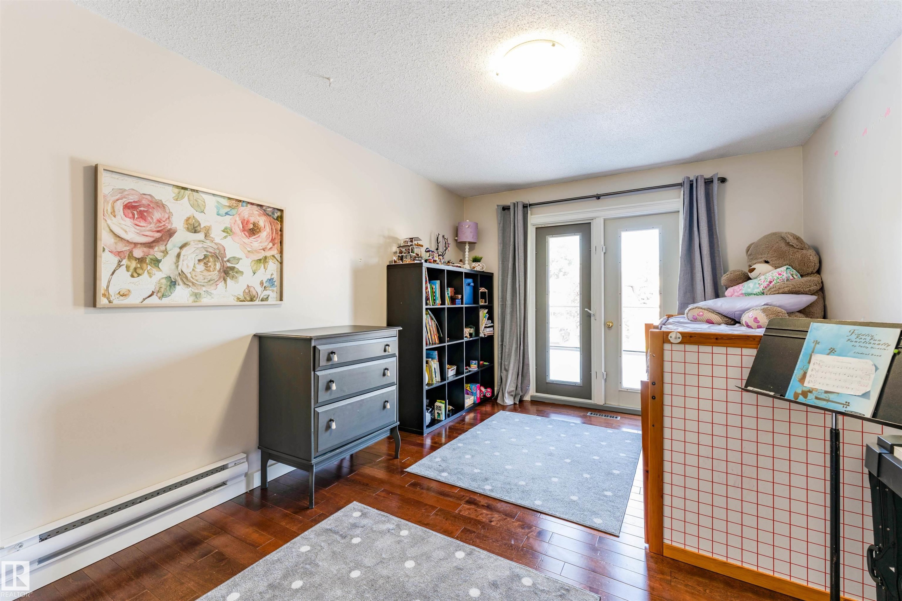 Room featuring wood-finish flooring, light-toned wall paint, and a ceiling-mounted flush light fixture - 5212 142 Street Nw, Edmonton, AB