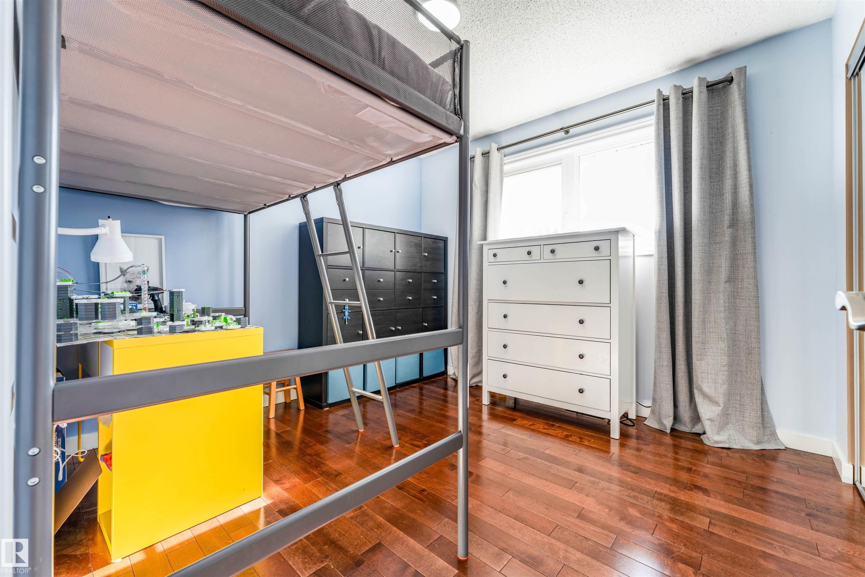 Rich wood-finish flooring complements light blue wall tones - 5212 142 Street Nw, Edmonton, AB
